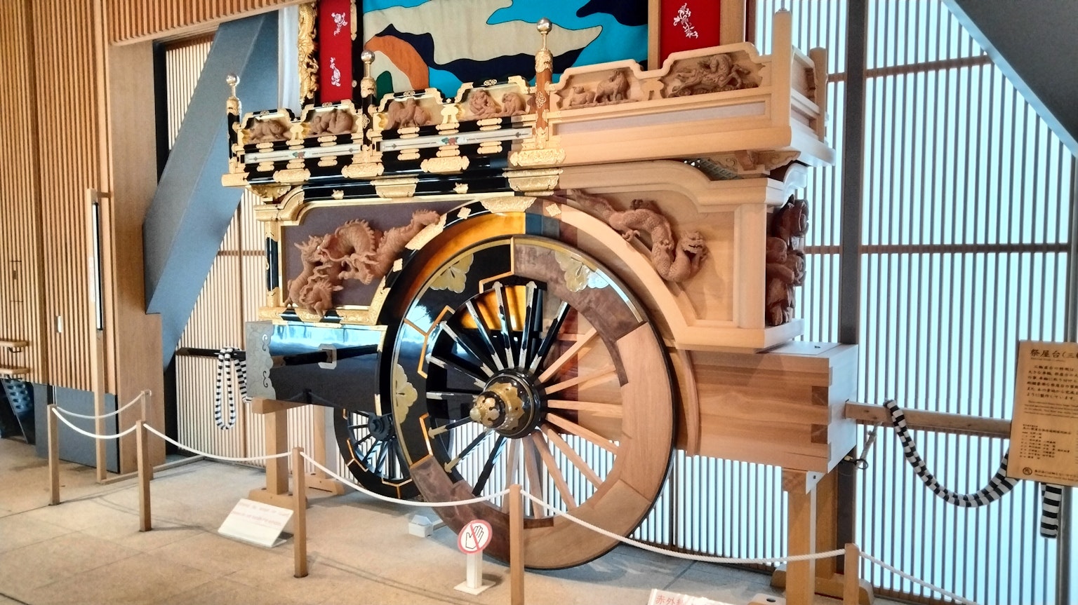 Carrello tradizionale in legno con ruota decorativa esposto all'interno