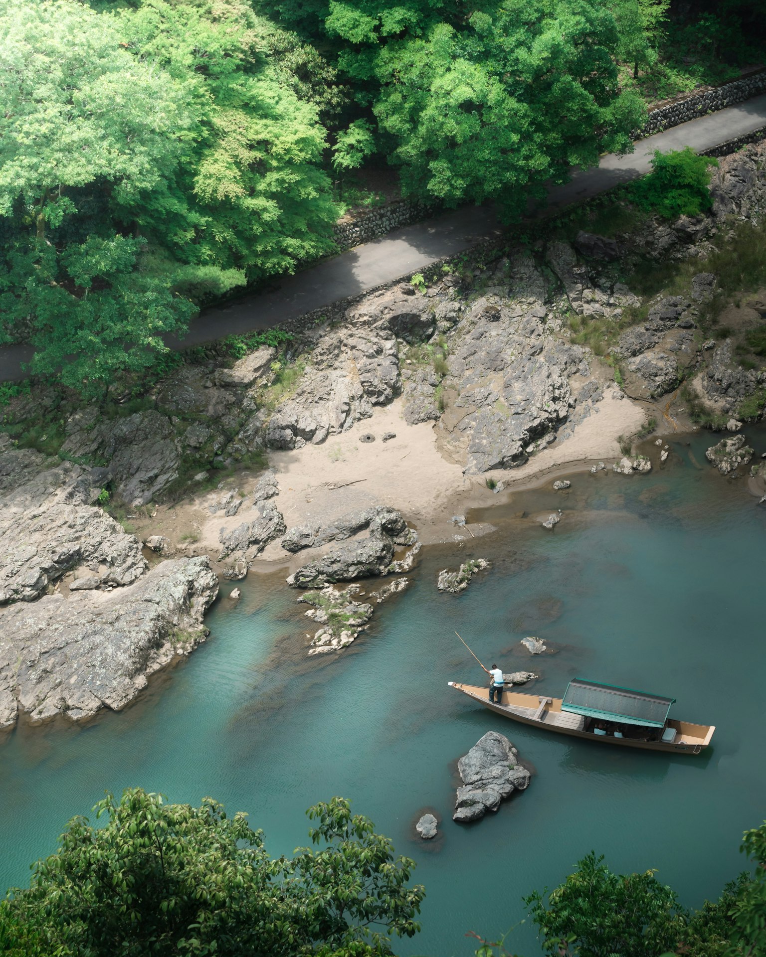 A small boat on a river surrounded by greenery and rocks