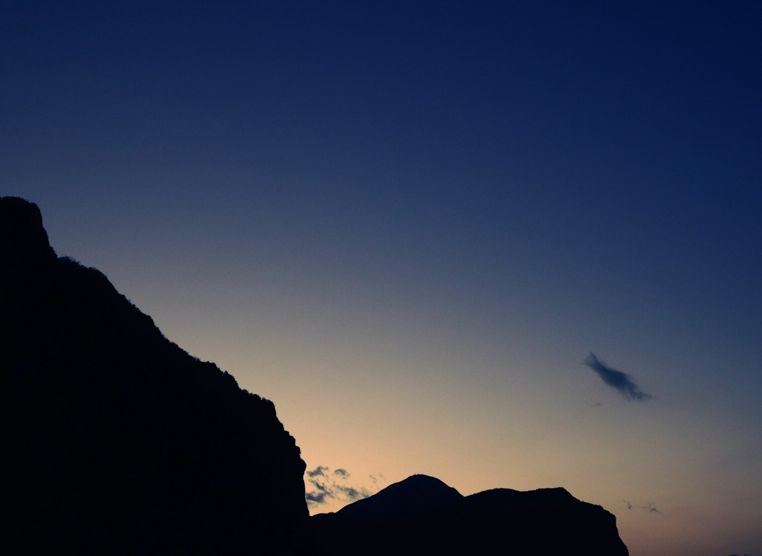 夕暮れ時の山のシルエットと青い空
