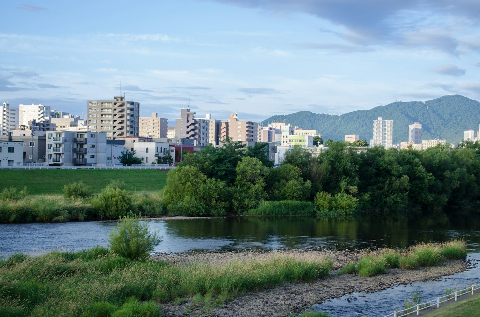 River and urban landscape with mountains in the background