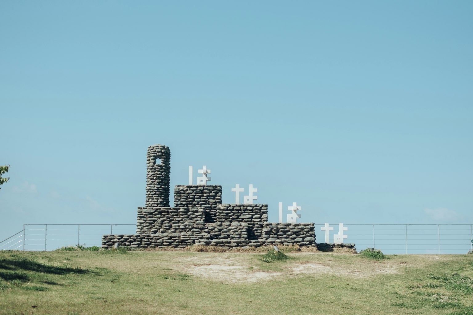 Monumento in pietra con lettere bianche sotto un cielo blu chiaro