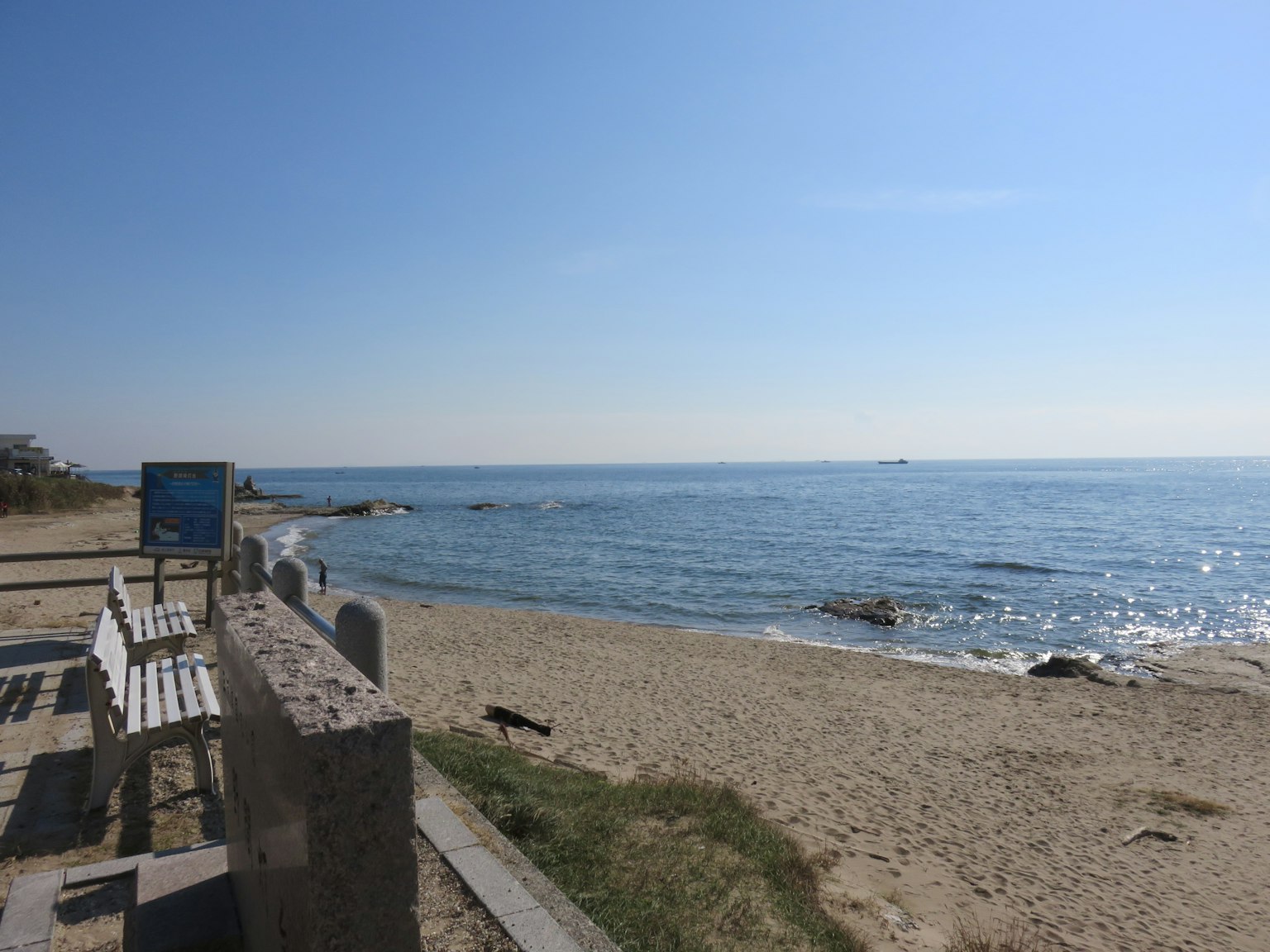 Vue côtière avec des vagues calmes et une plage de sable