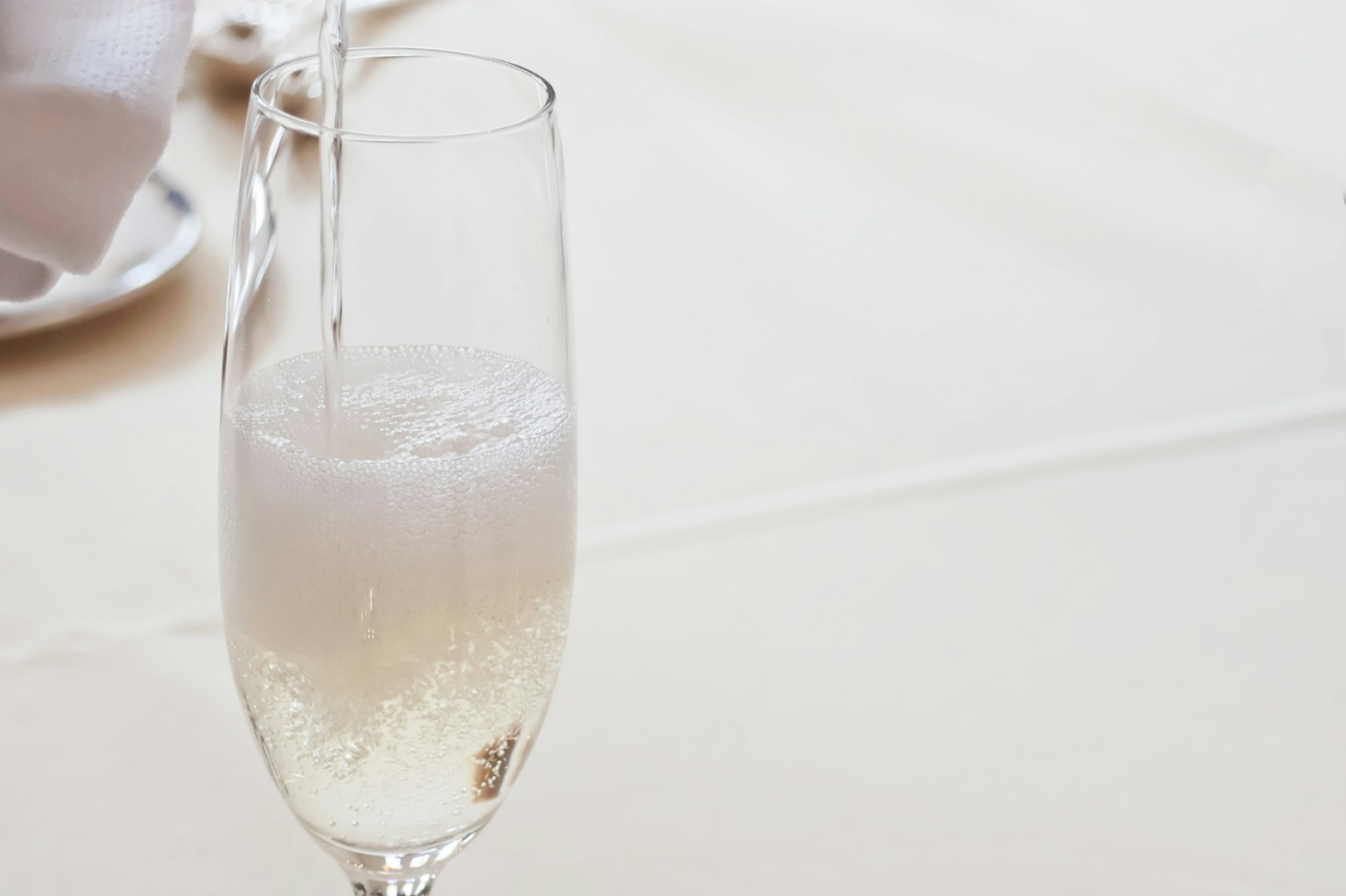 Una bevanda frizzante versata in un bicchiere di champagne trasparente