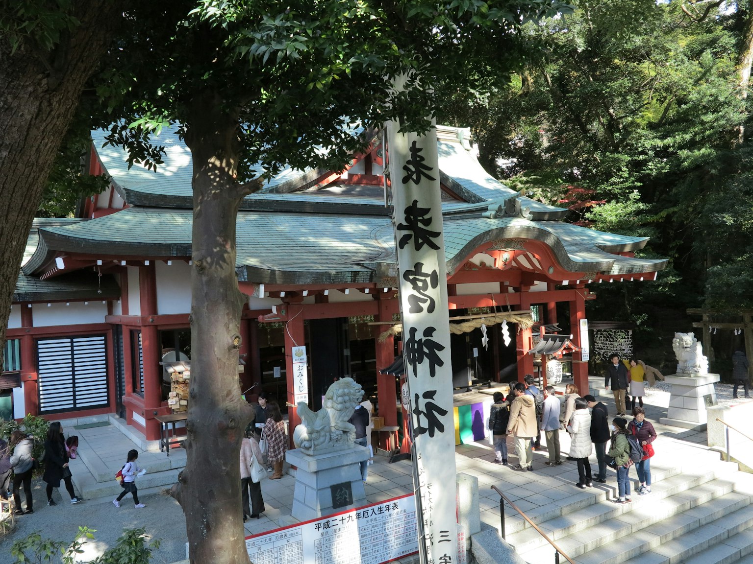 传统日本神社建筑被树木环绕，游客众多