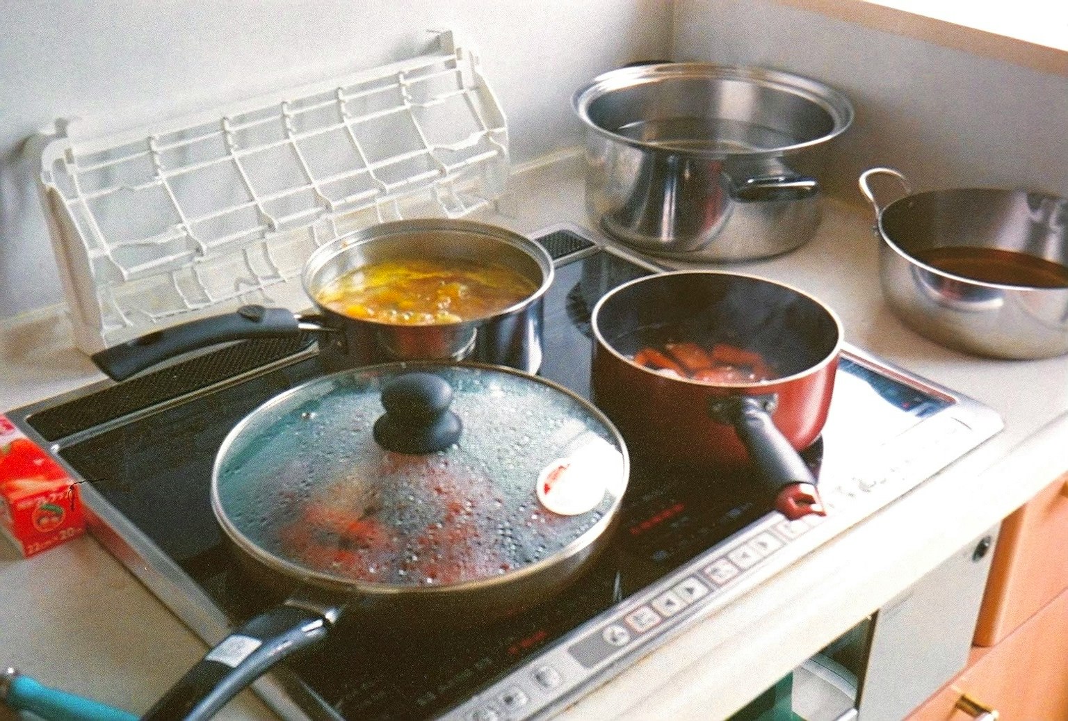 주방 스토브 위에 여러 개의 냄비가 끓고 있는 모습