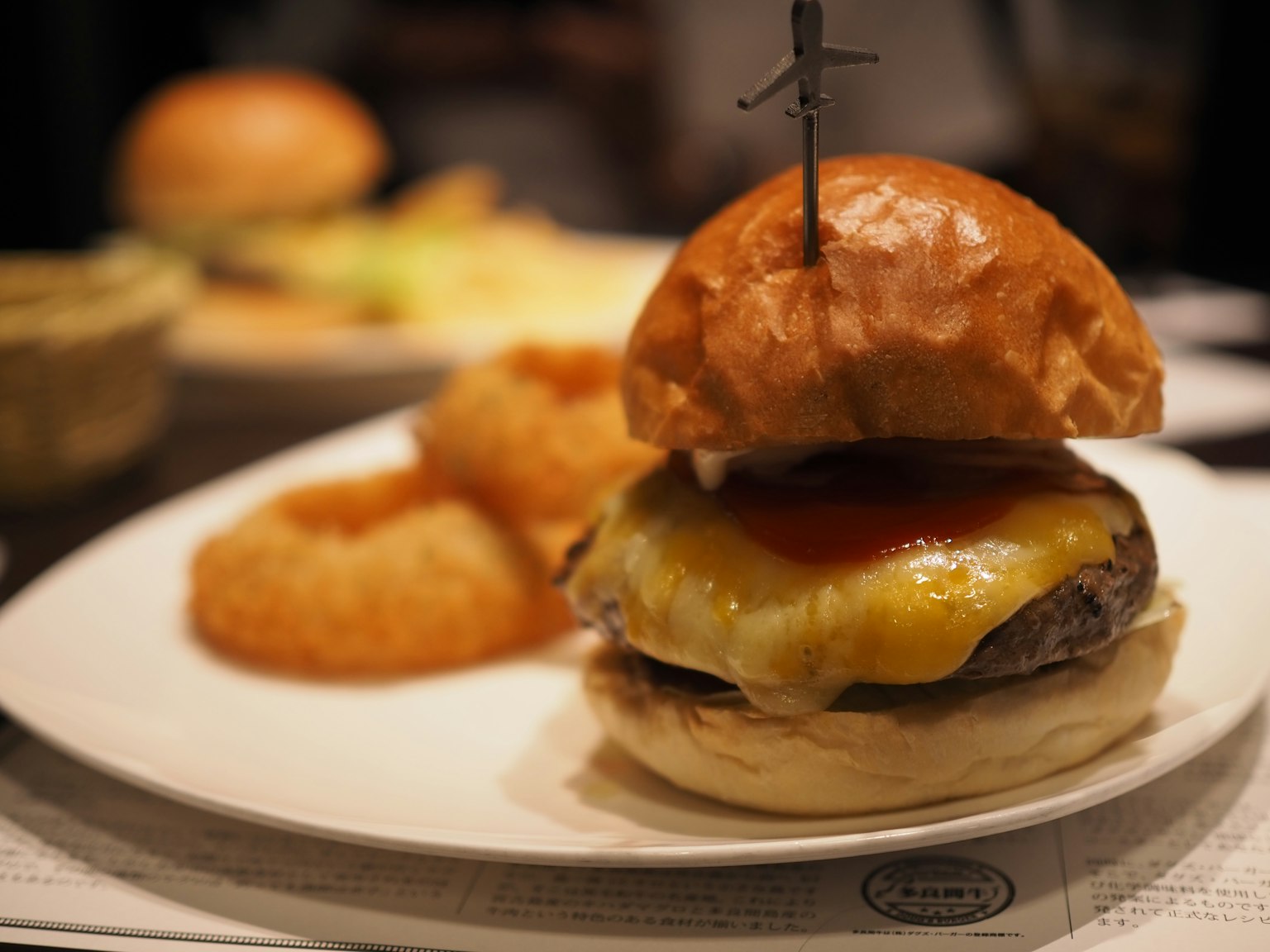 Delicioso hamburguesa con queso y ketchup servido con aros de cebolla