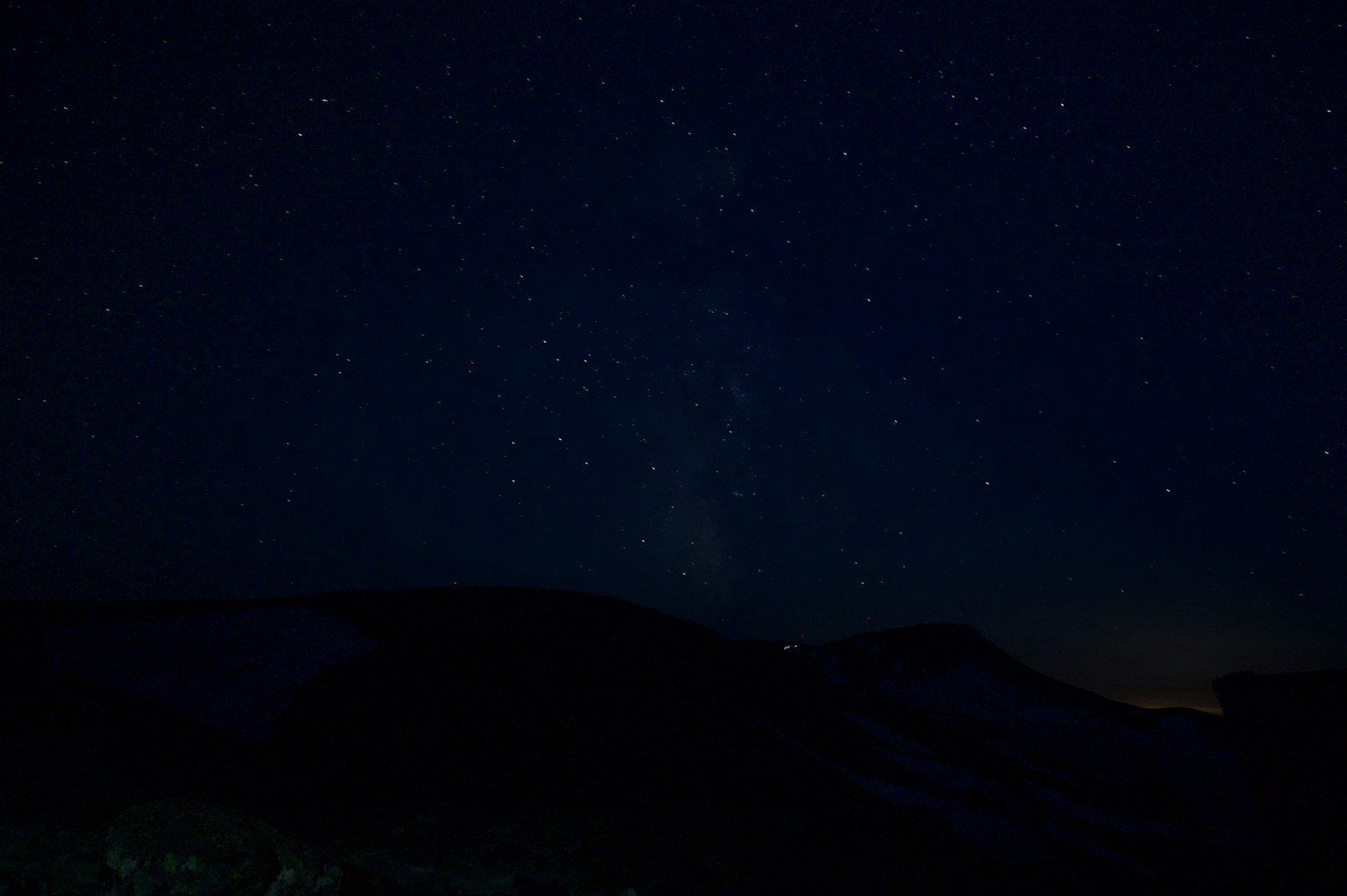 Langit malam dipenuhi bintang dan siluet gunung