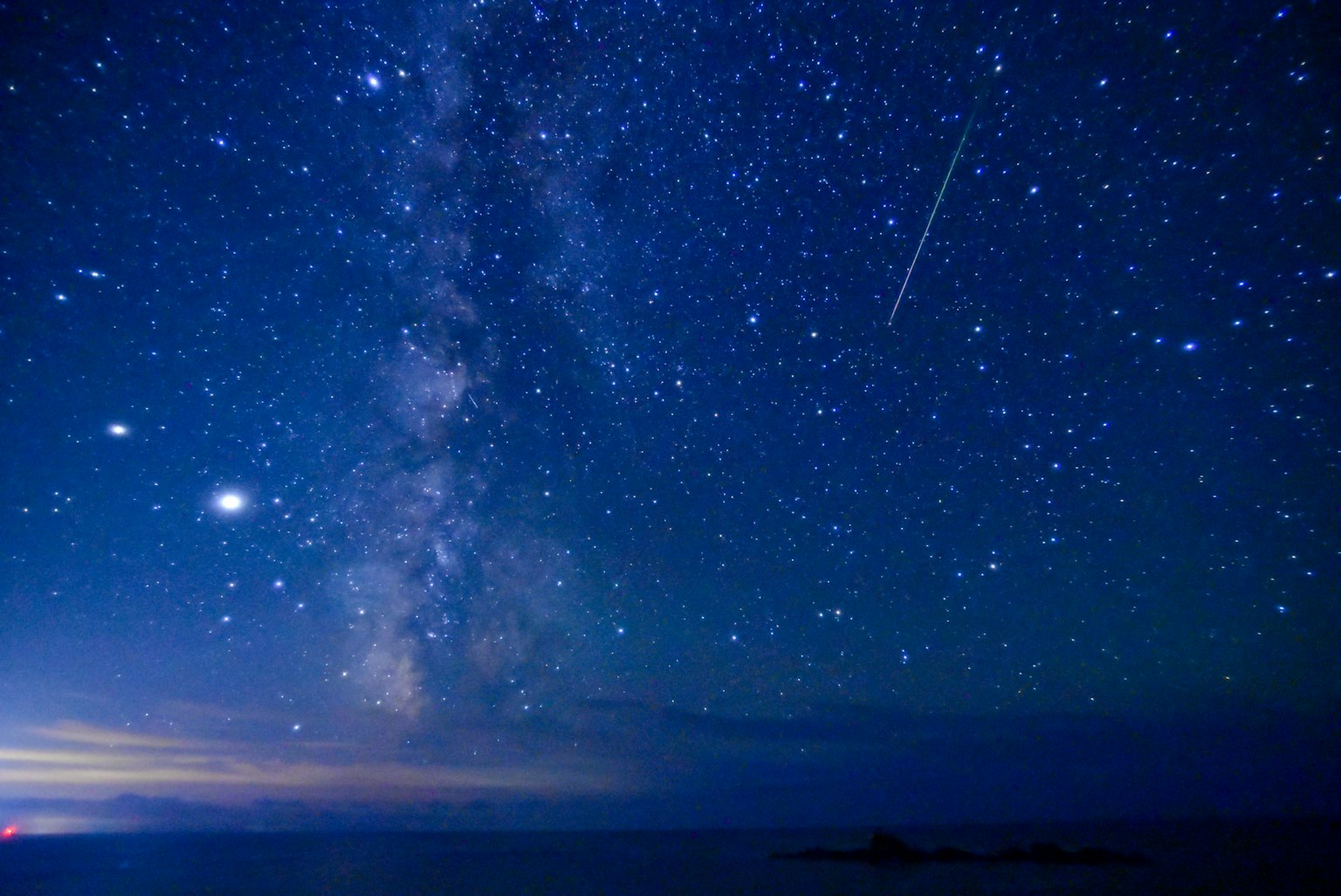 Hermoso cielo nocturno con la Vía Láctea y una estrella fugaz