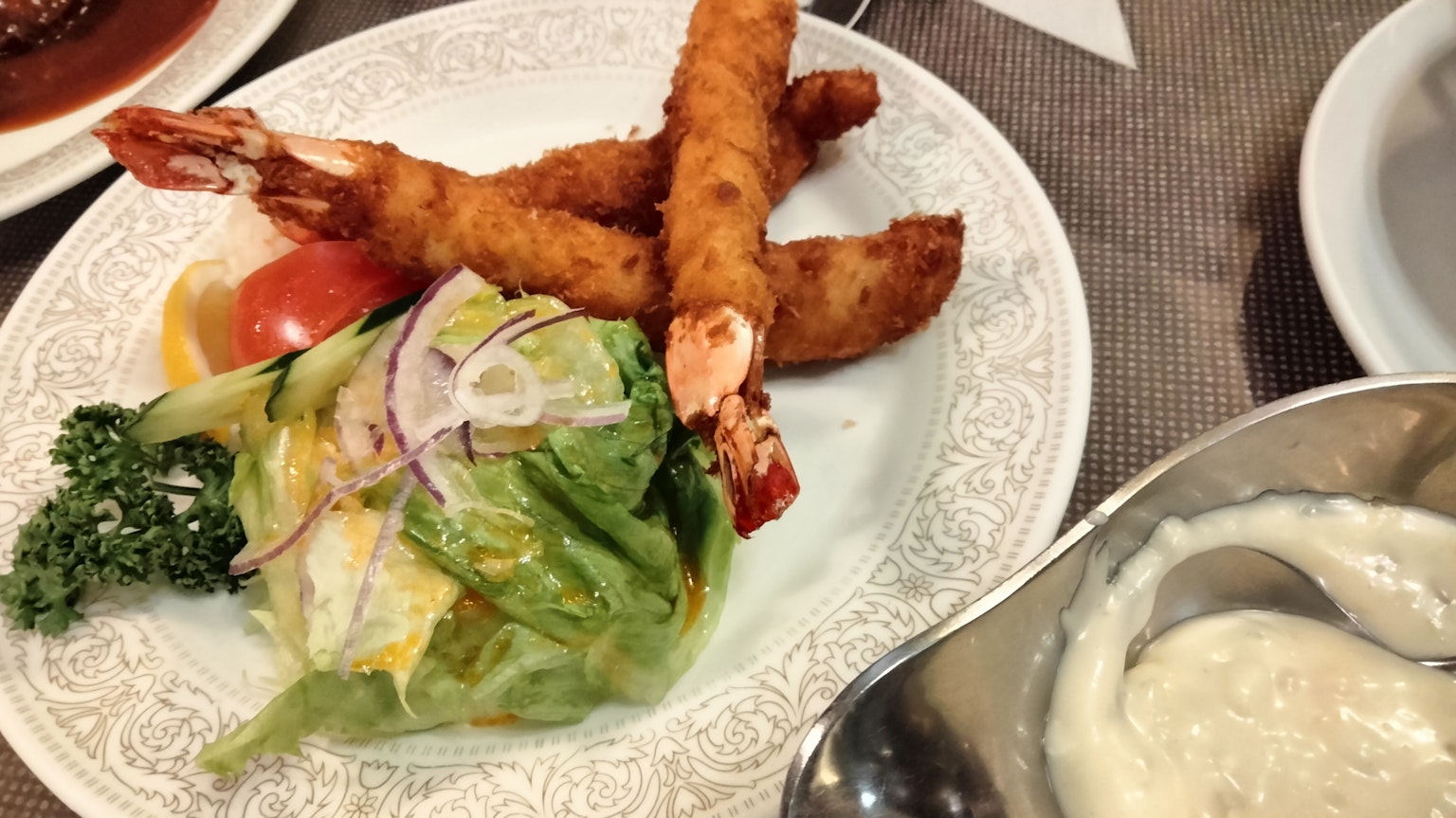 Plato con camarones fritos y ensalada fresca con lechuga y tomates