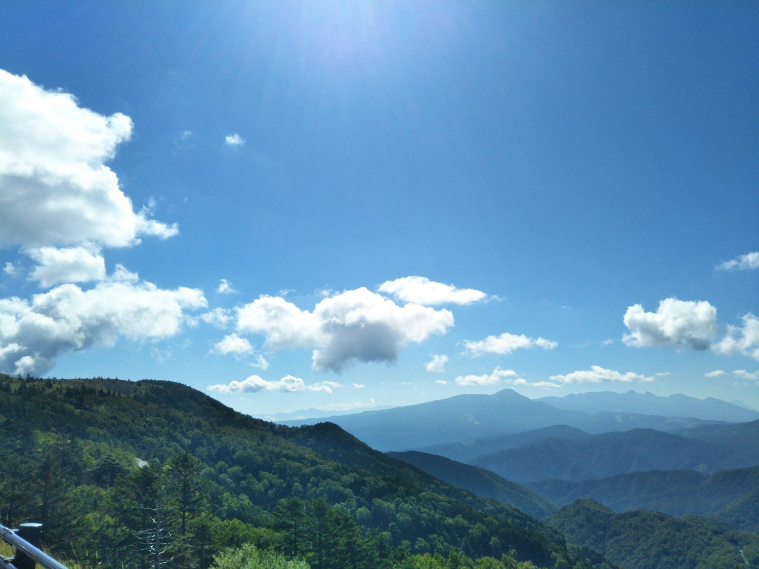 Bellissimo paesaggio montano con cielo blu e nuvole colline verdi e montagne lontane