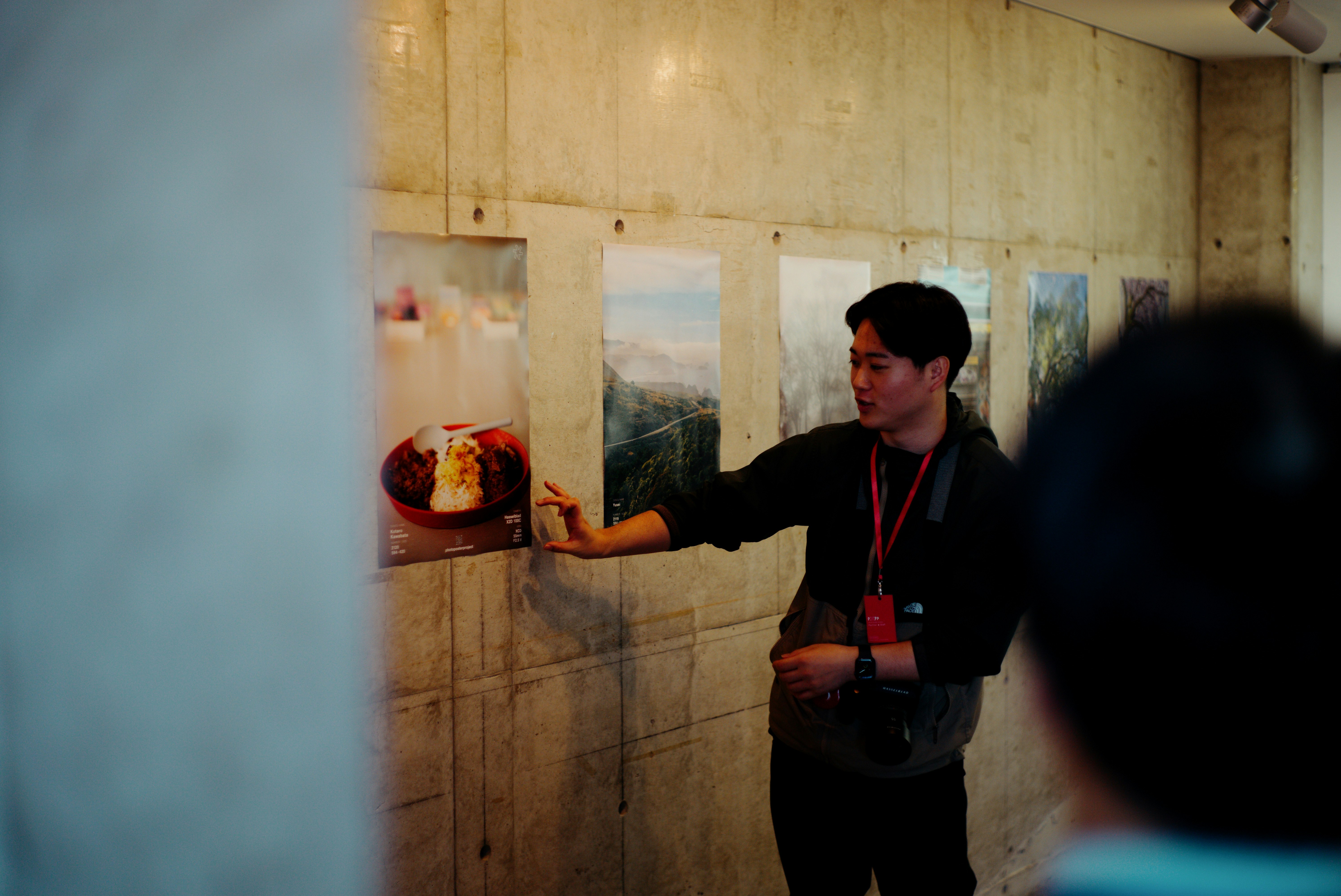 奈良の壁面展示を見つめる人物とポスター制作の雰囲気