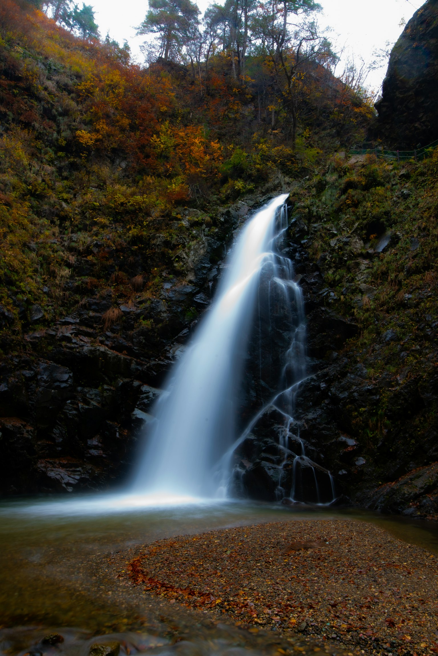 Hermosa cascada que cae en un paisaje otoñal