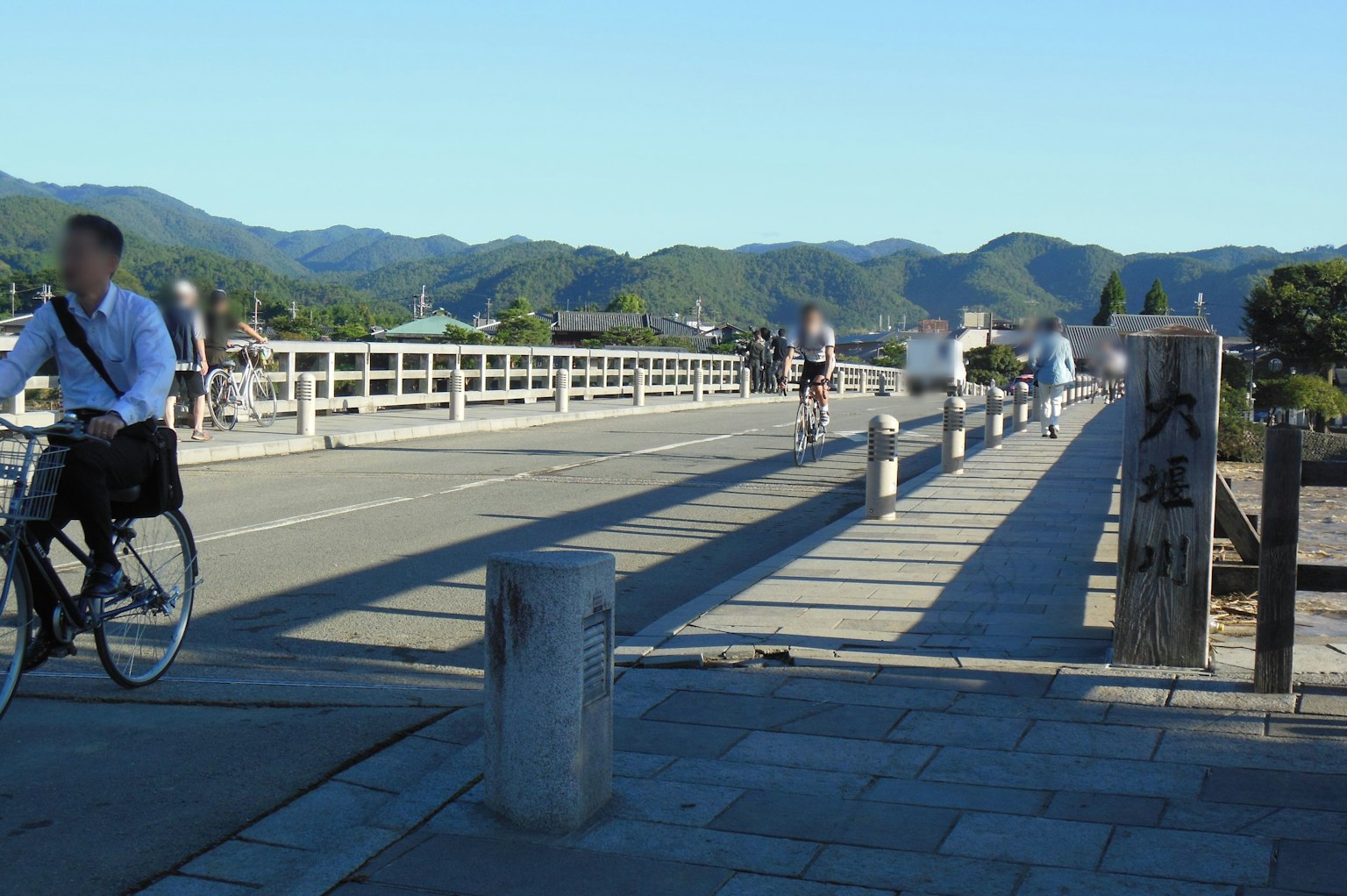 View of a bridge with a cyclist and distant mountains