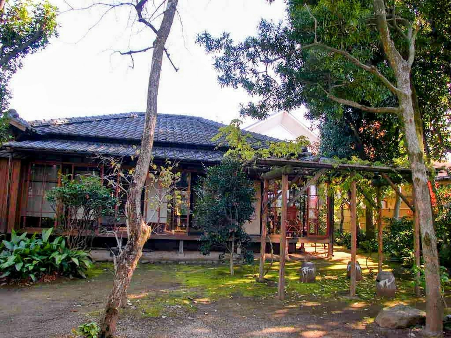 Maison japonaise traditionnelle entourée de verdure et de jardin