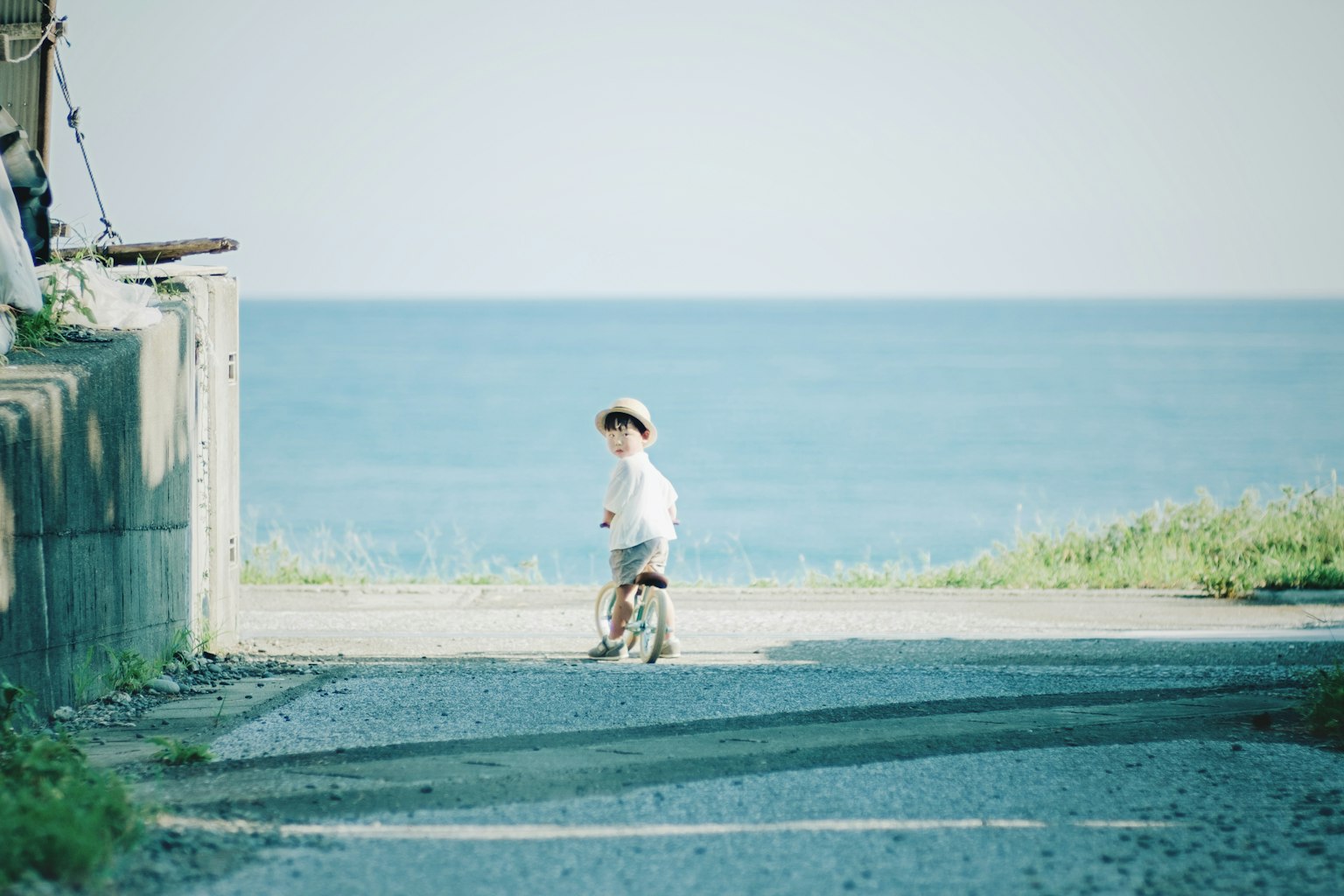 Un niño montando una bicicleta cerca del mar