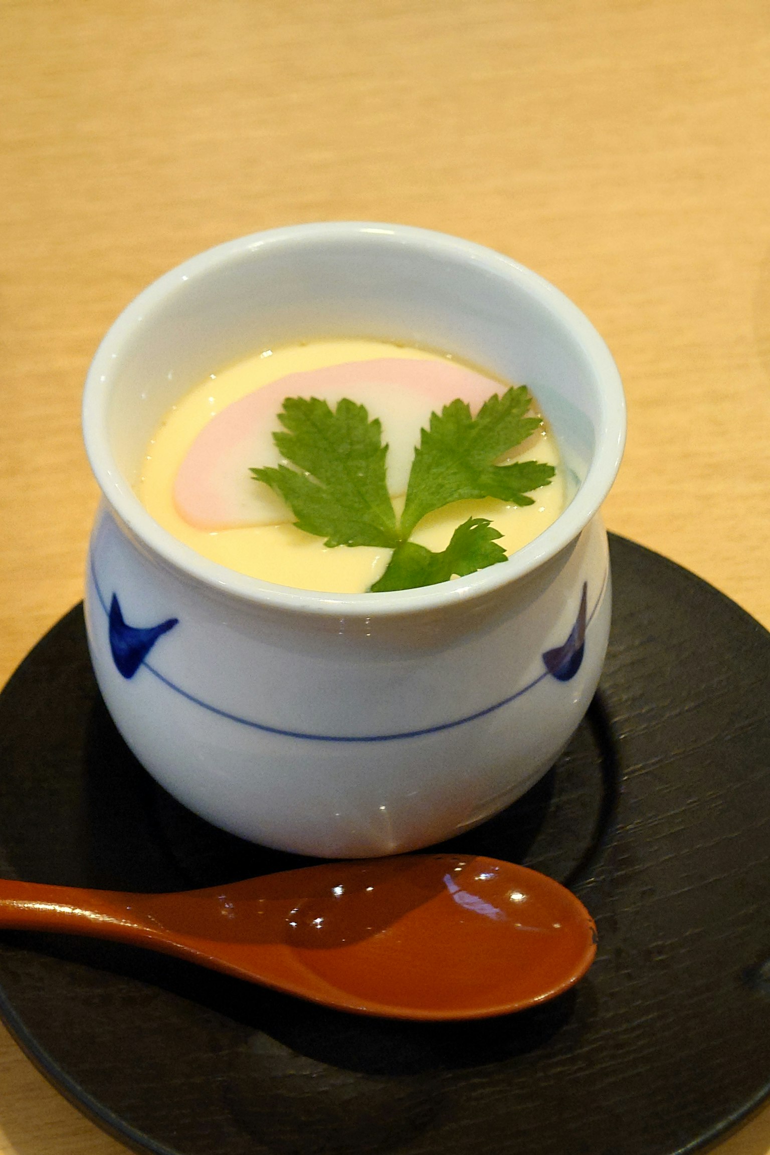 Chawanmushi dalam cangkir putih dihiasi daun ketumbar