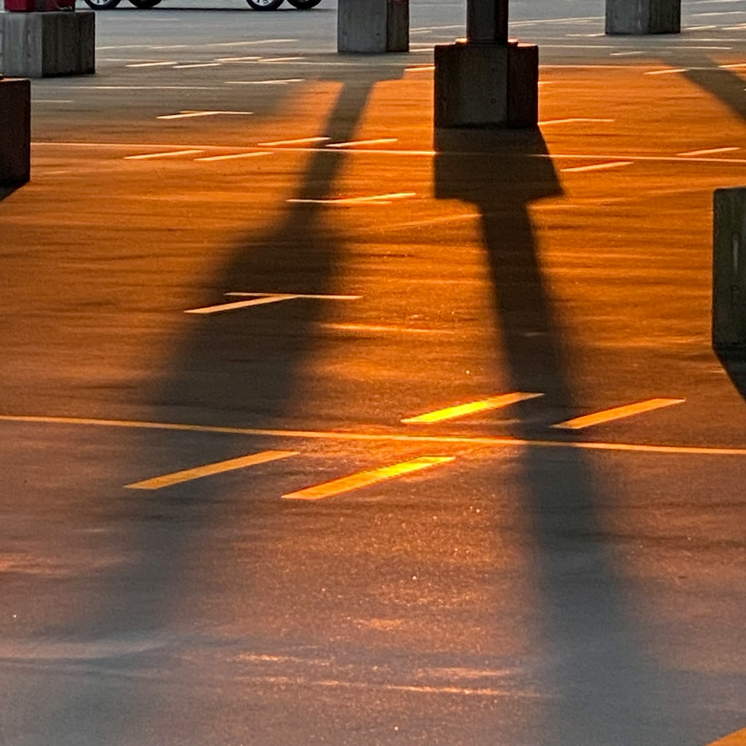 Orange light and shadows on a parking lot floor