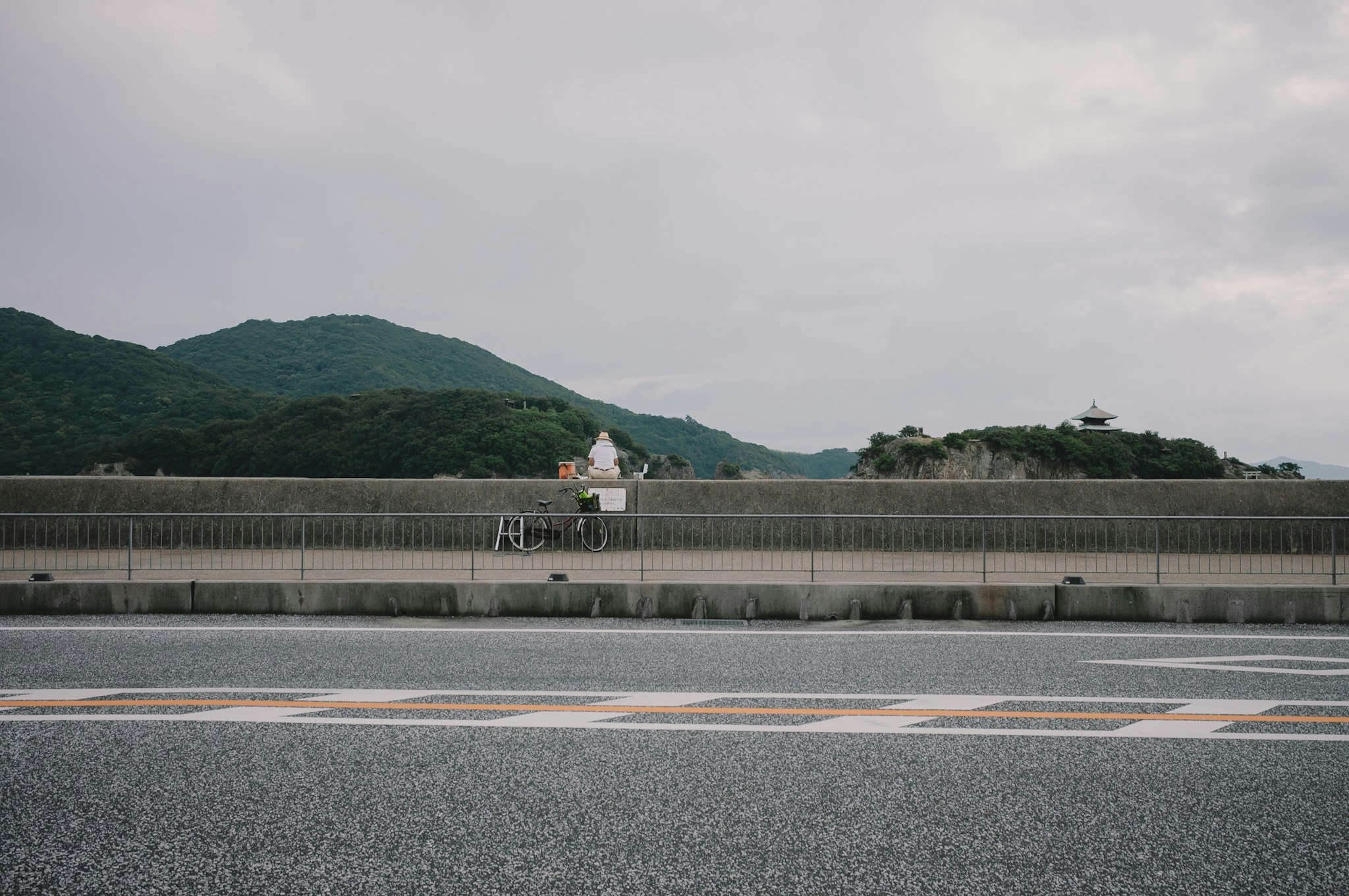 山と静かな海岸線が広がる風景に小さな建物が見える