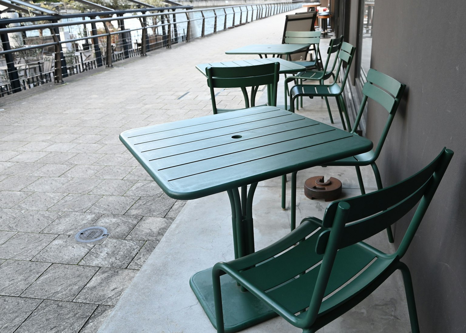Terrassenansicht mit grünen Tischen und Stühlen