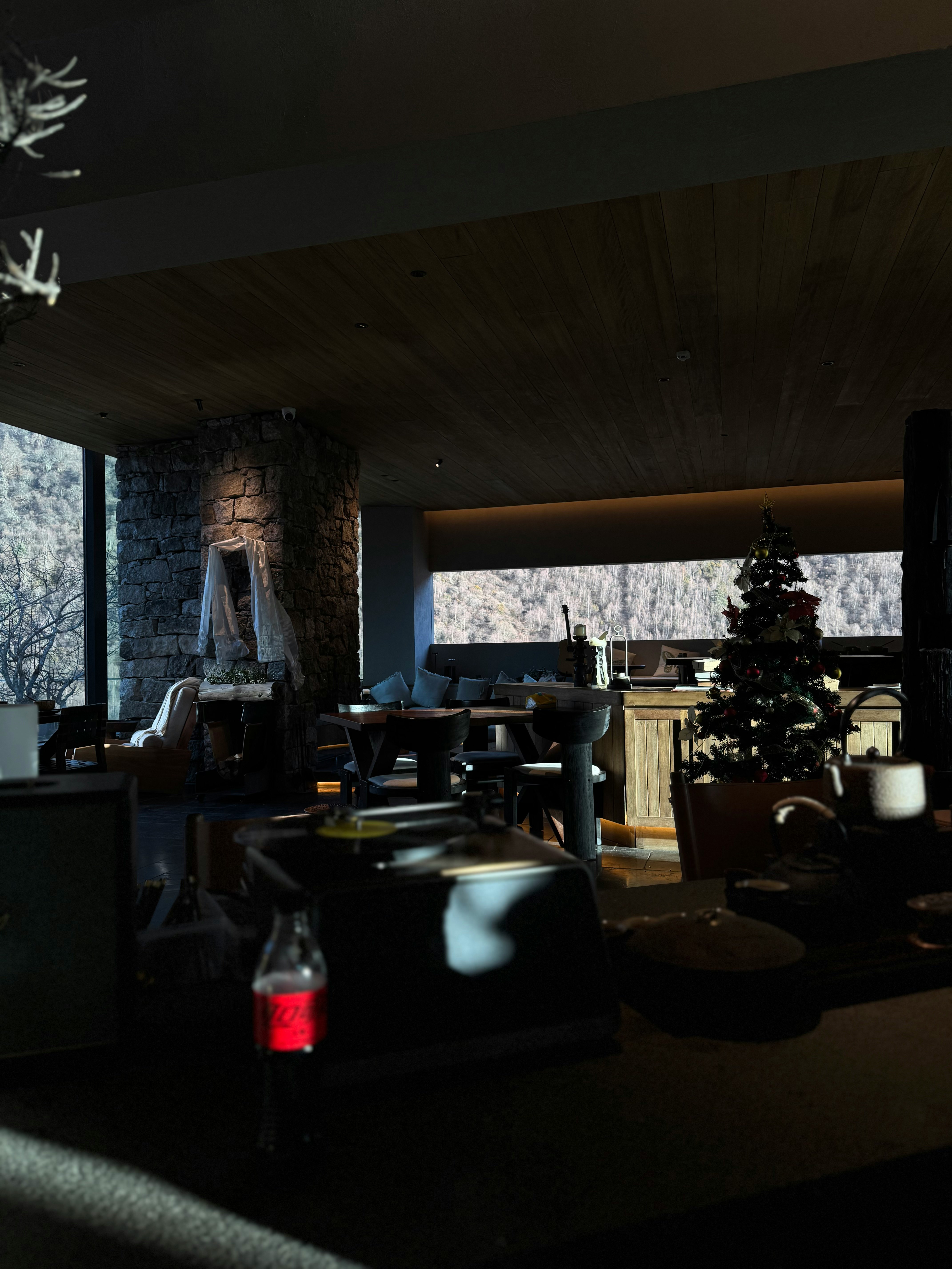 scena interna con tavolo di legno vicino a una finestra e albero di Natale