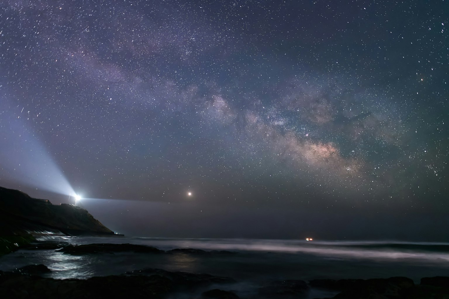星空下的海洋景觀，燈塔和閃耀的銀河