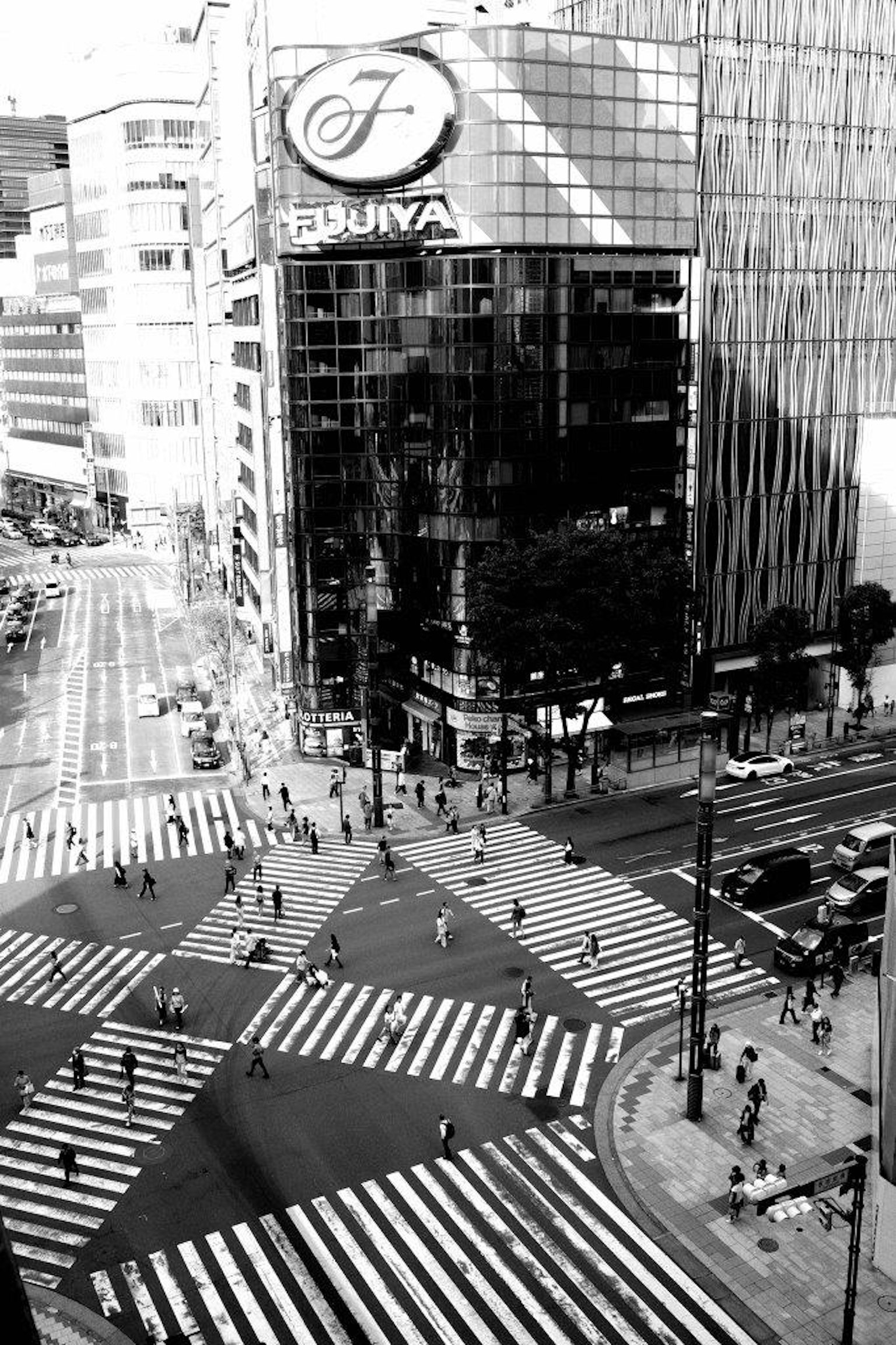 Foto in bianco e nero dell'incrocio di Shibuya che mostra molti pedoni sui marciapiedi