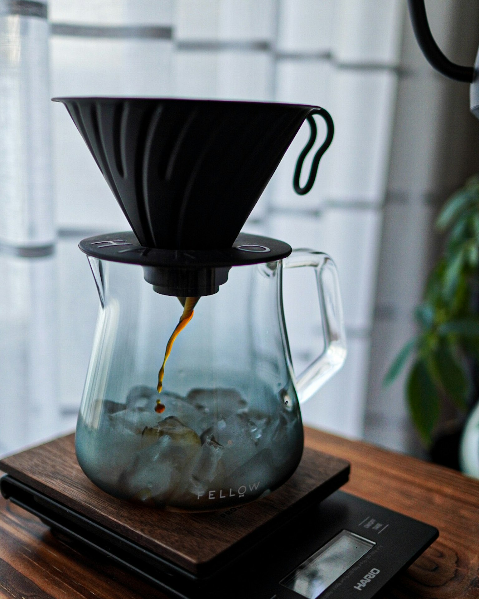 กาแฟเทลงบนก้อนน้ำแข็งในแก้วใสพร้อมตัวกรองสีดำ