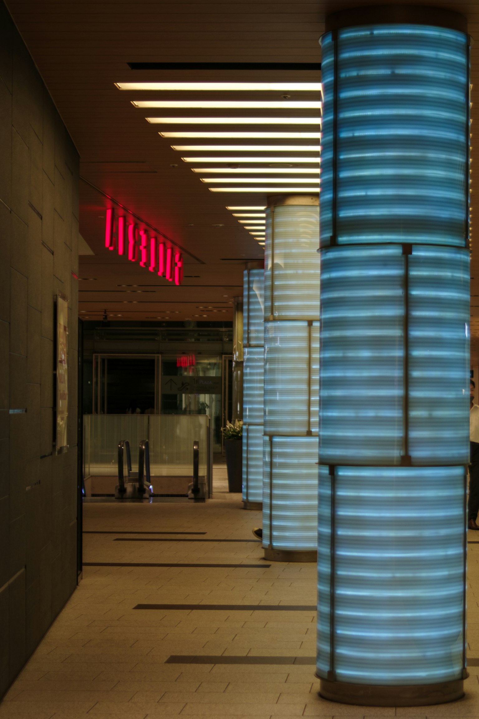 Entrada con columnas azules iluminadas y diseño interior moderno