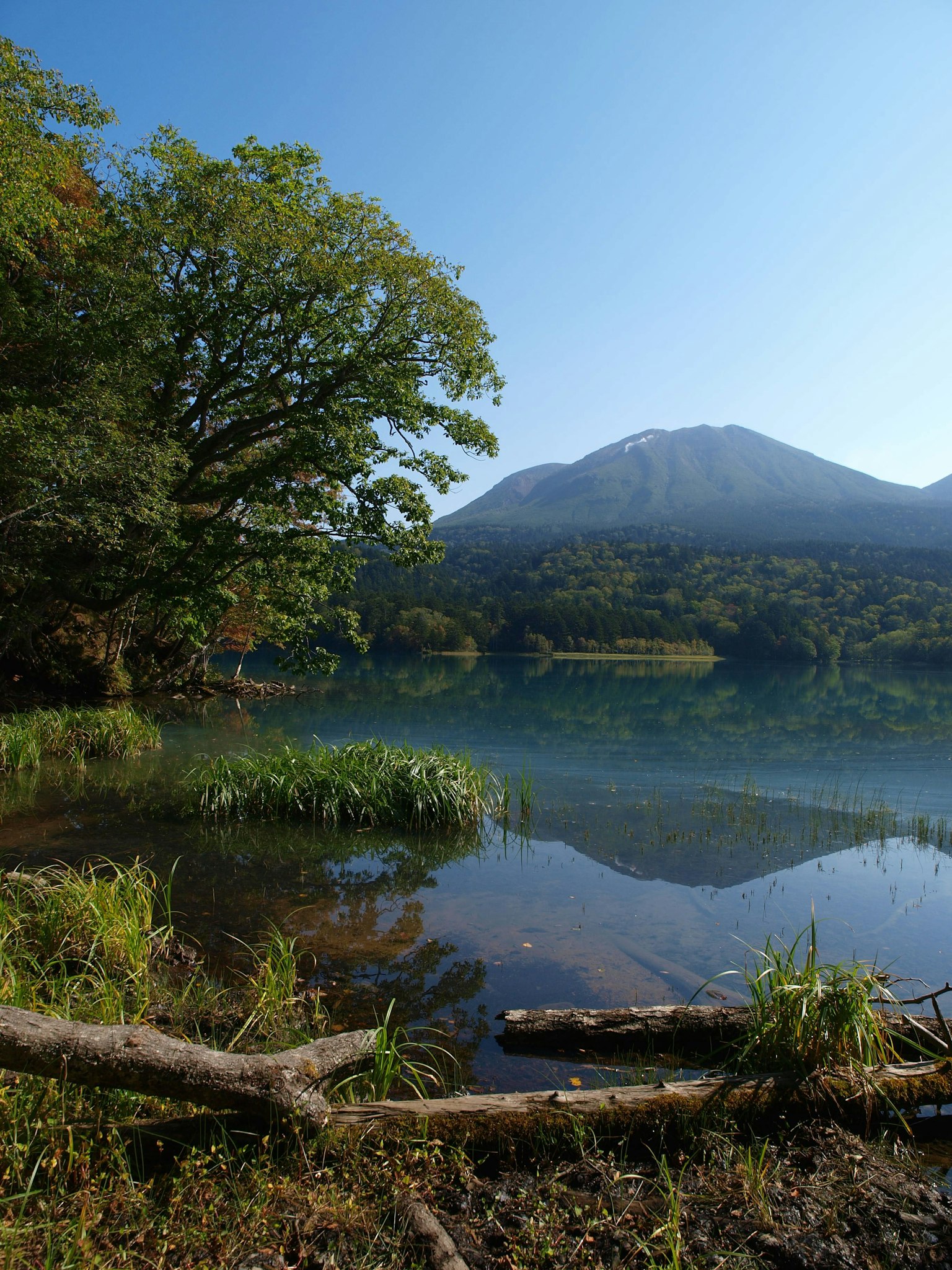 静かな湖と青空の下、山が映る風景