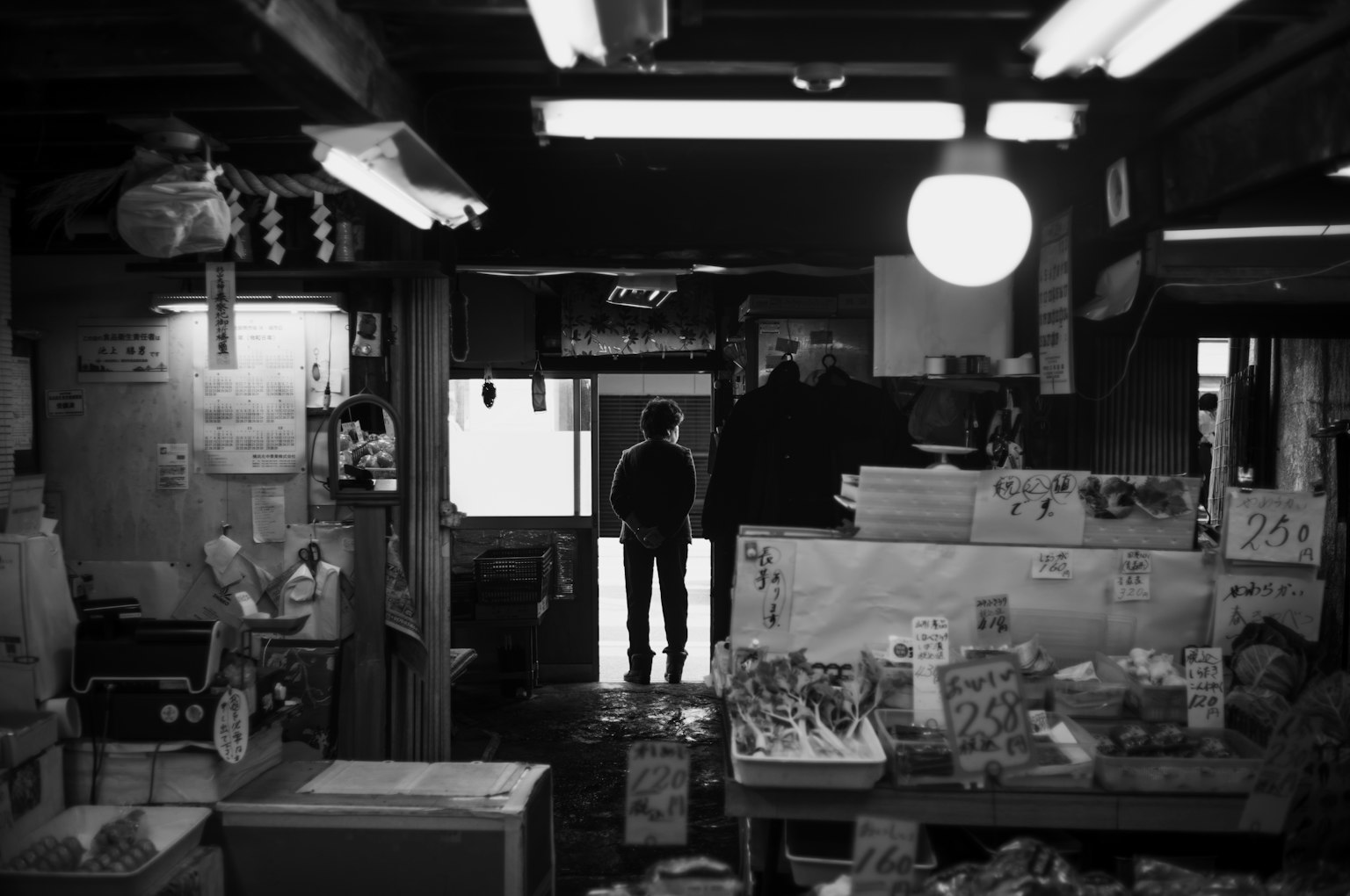 Intérieur d'un vieux magasin avec une personne debout en noir et blanc