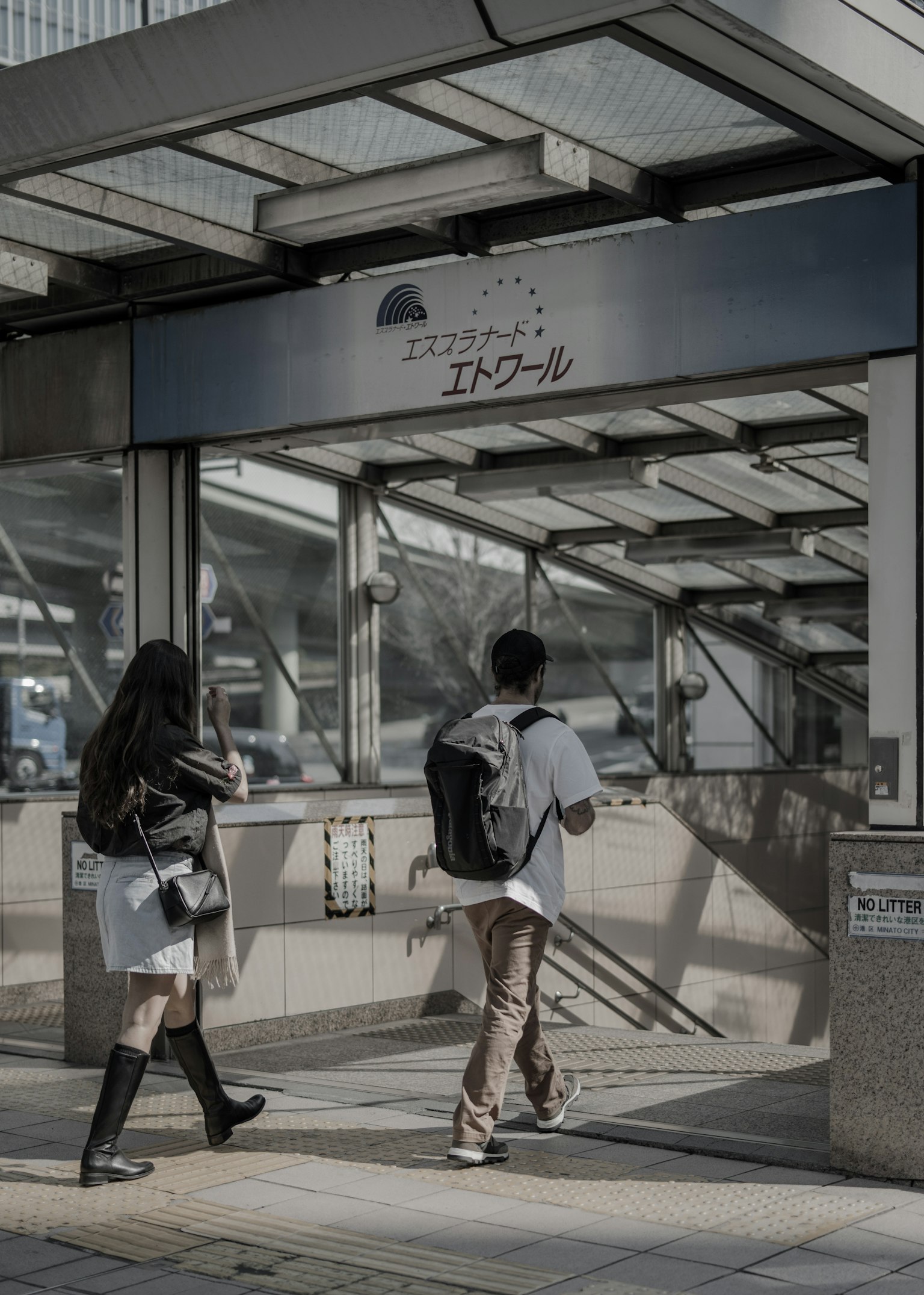 Dos jóvenes caminando hacia la entrada de una estación de tren