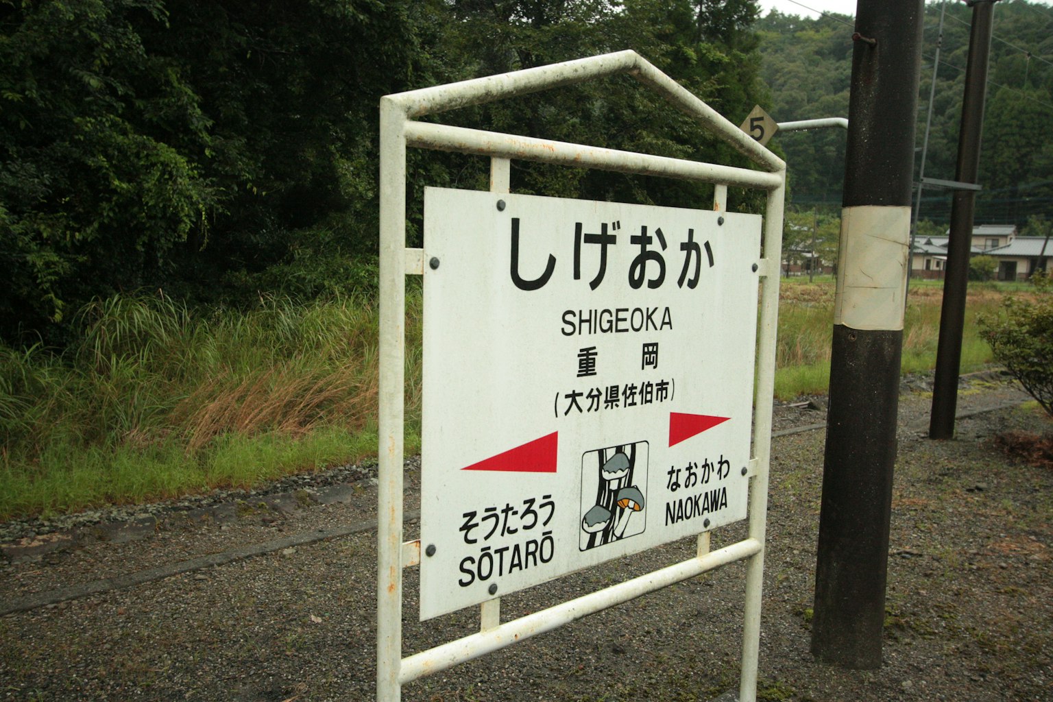 Segnale della stazione di Shigeoka con vegetazione circostante