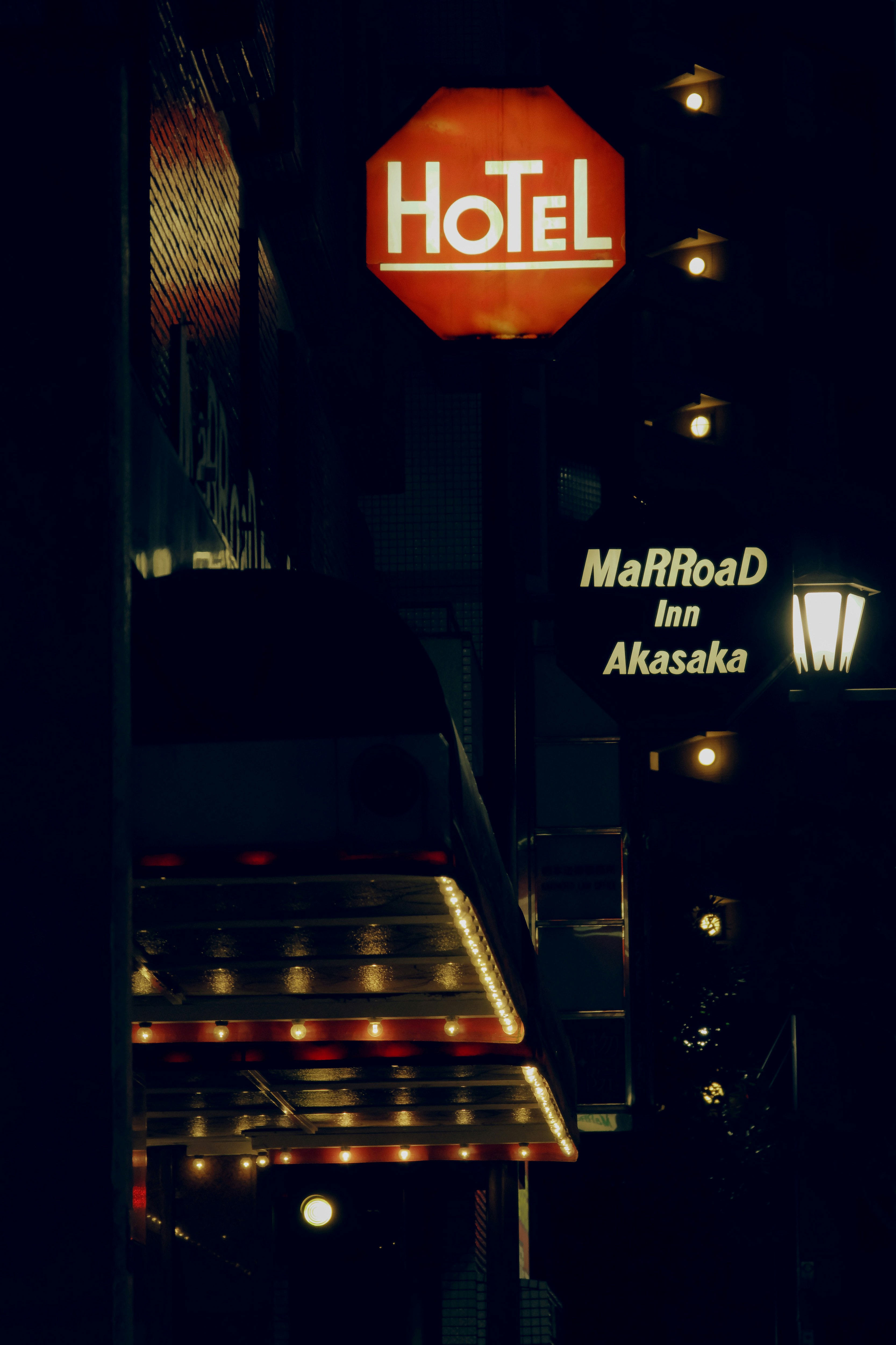 夜晚的酒店入口，发光招牌与路灯