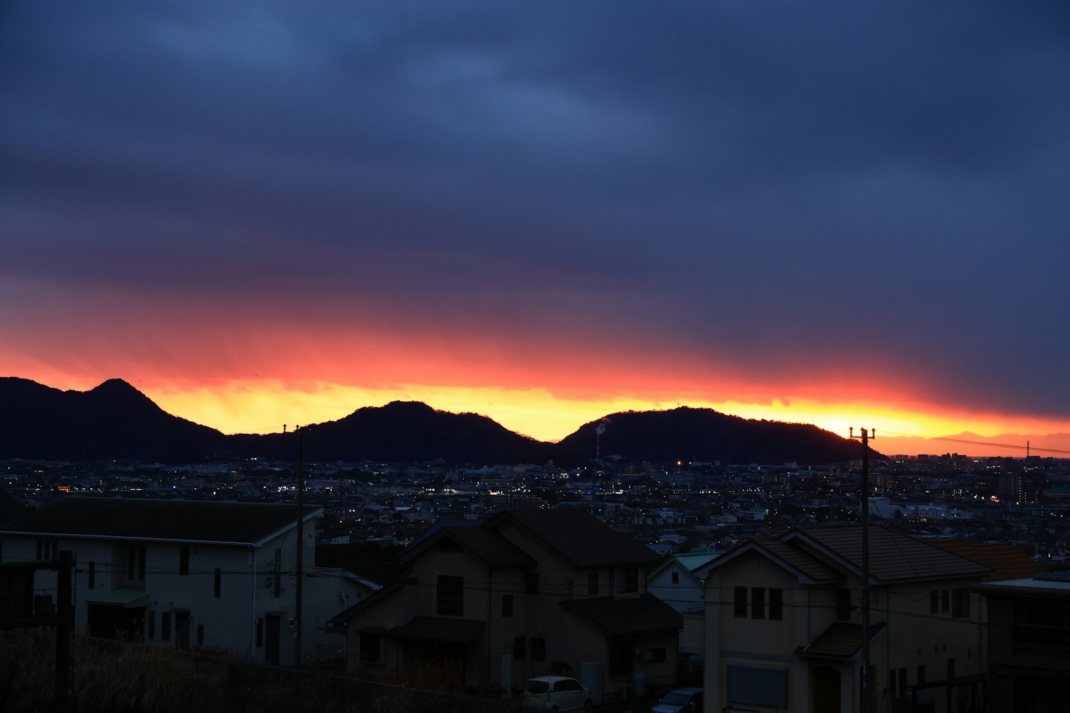 夕焼けの美しい風景に山々と街の明かりが映える