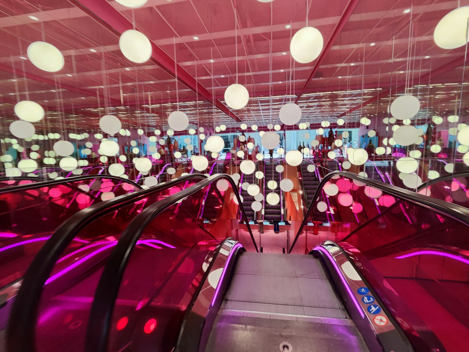 Modern interior with escalators and colorful hanging lights
