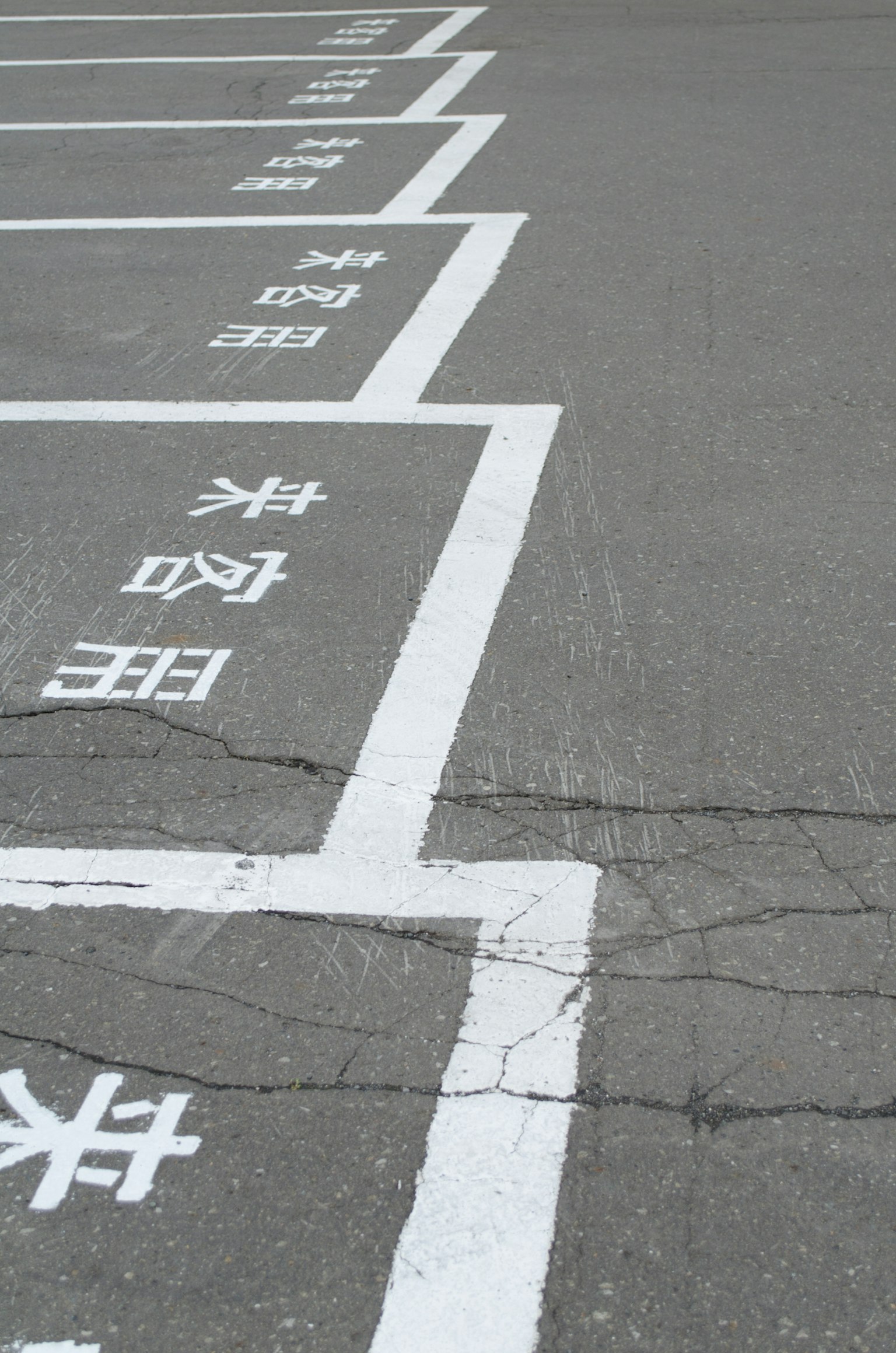 Parcheggio con linee bianche e caratteri cinesi sul pavimento