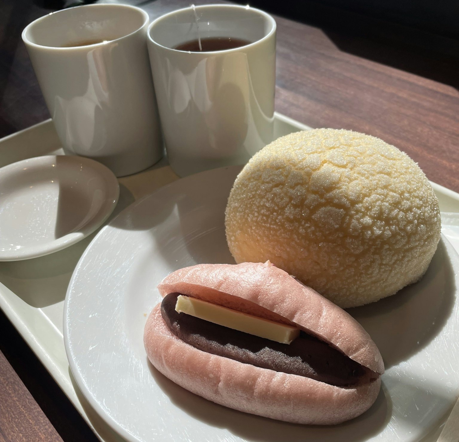 Dua cangkir teh dengan dua kue Jepang di atas piring