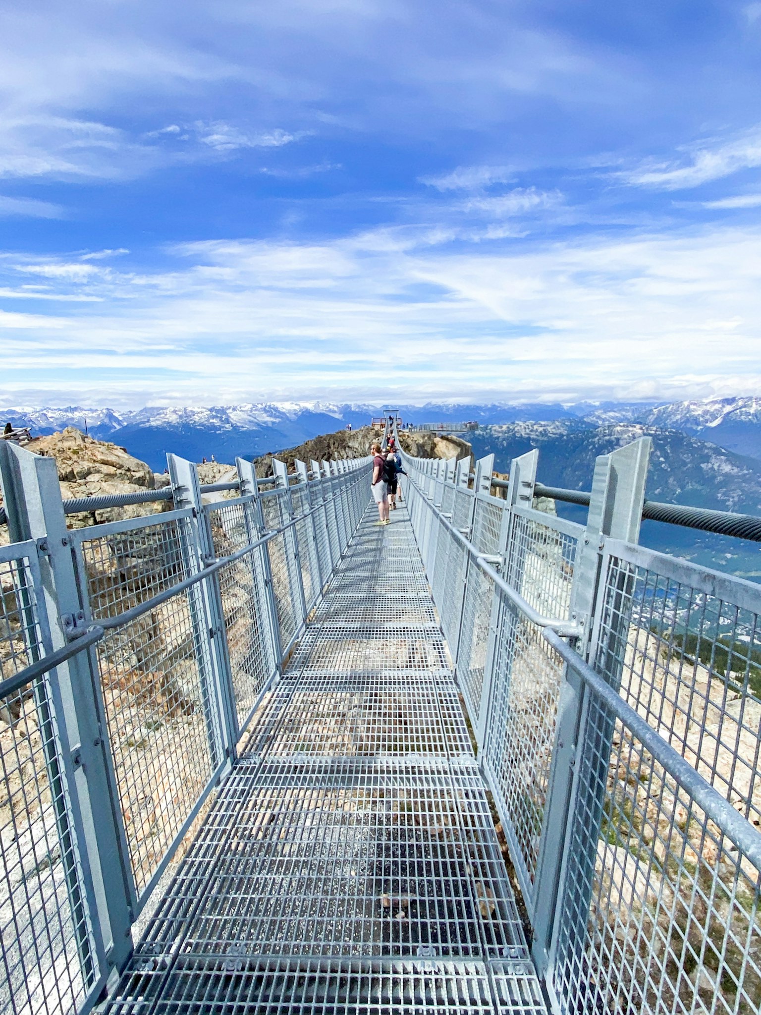 Passerelle en métal sur une montagne s'étendant dans un ciel bleu