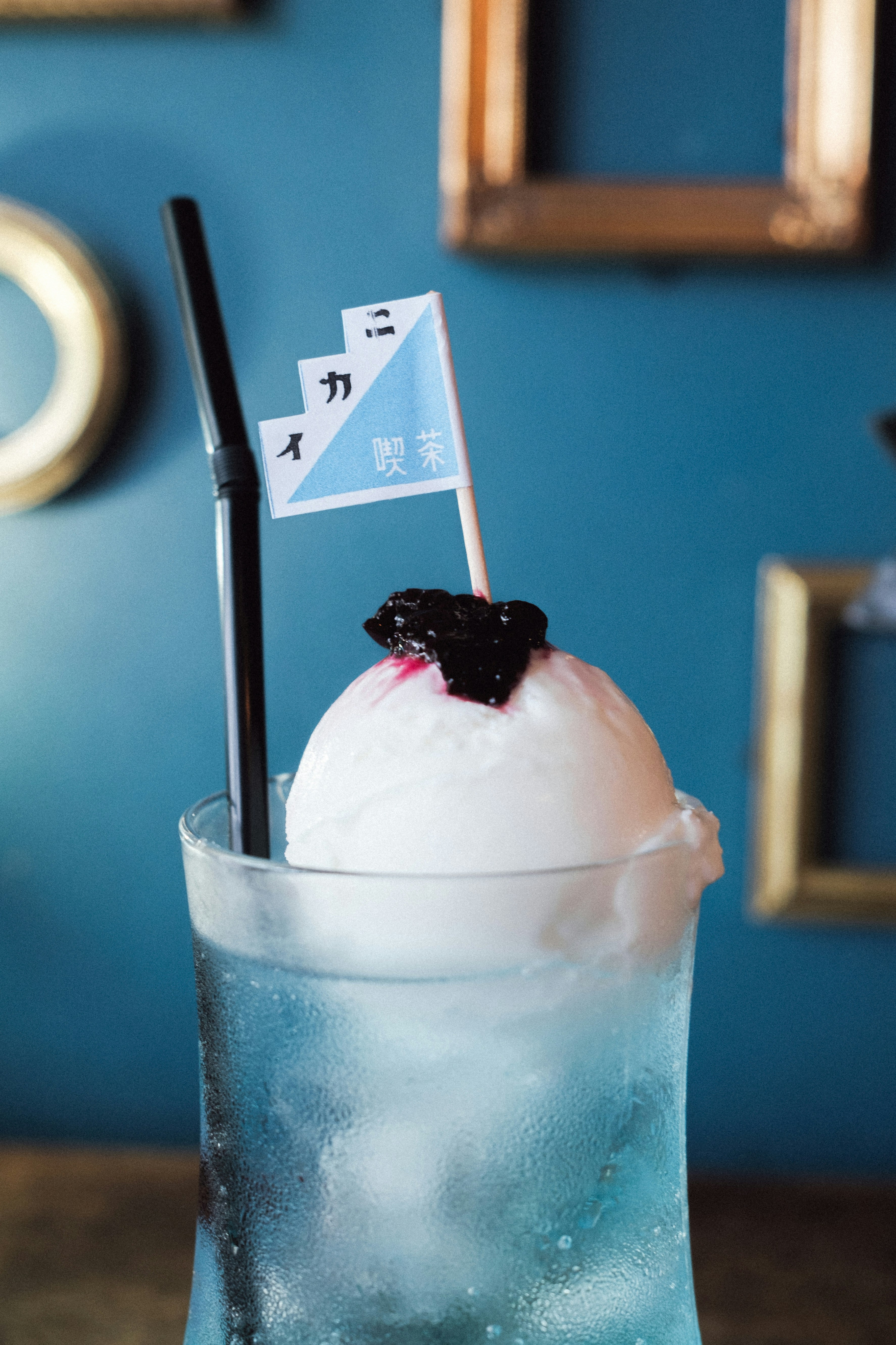 青い壁の店内でかき氷とストローのドリンク