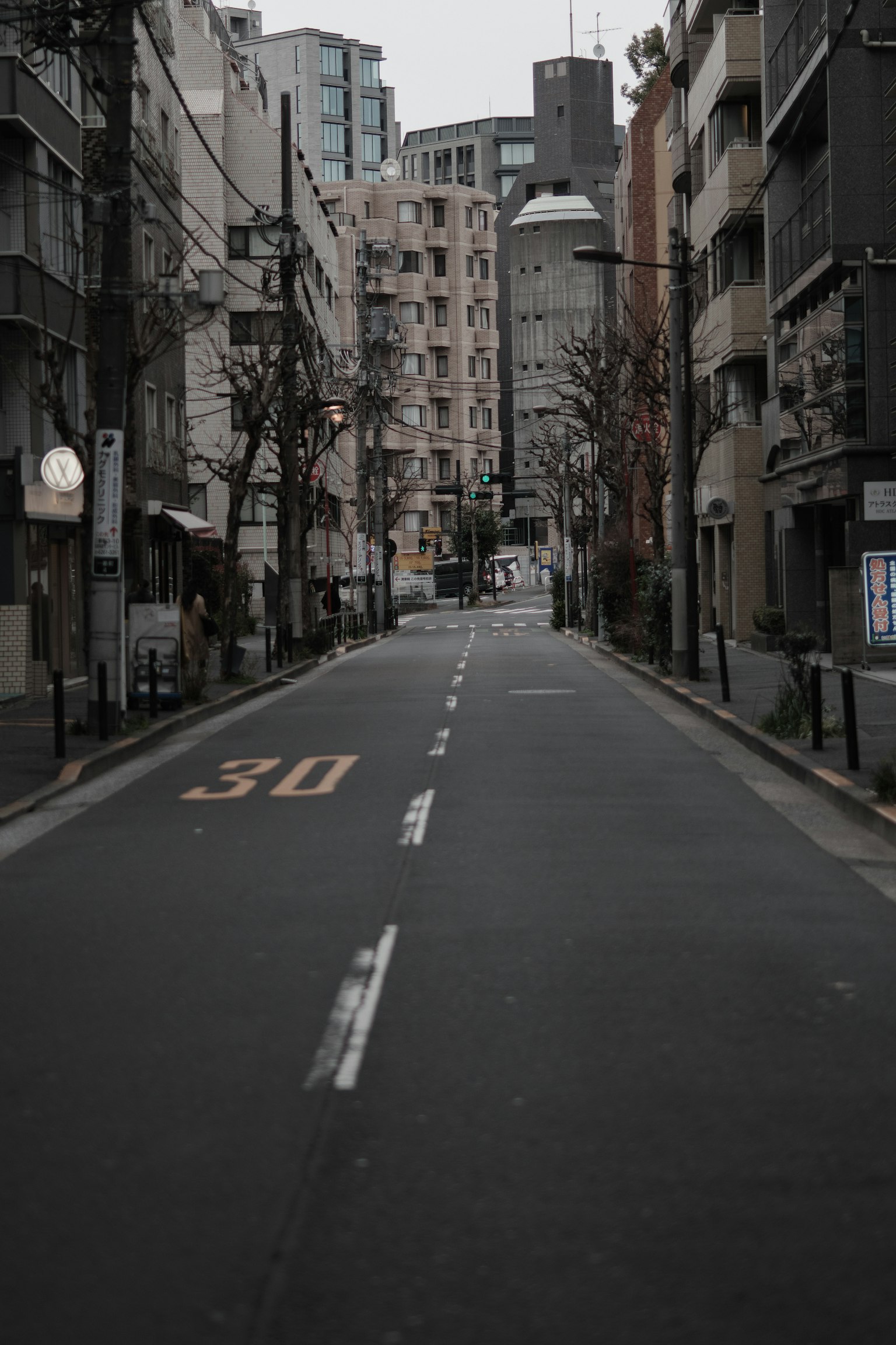 Strada urbana tranquilla con edifici allineati e un segnale di limite di velocità di 30 visibile