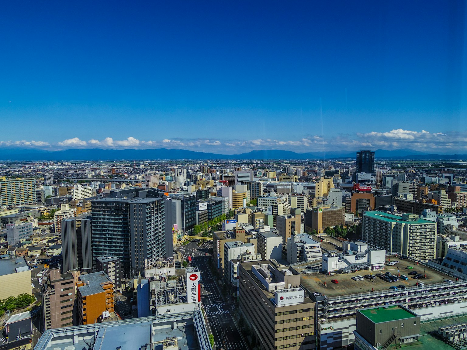 Vista panoramica della città con cielo azzurro e montagne sullo sfondo
