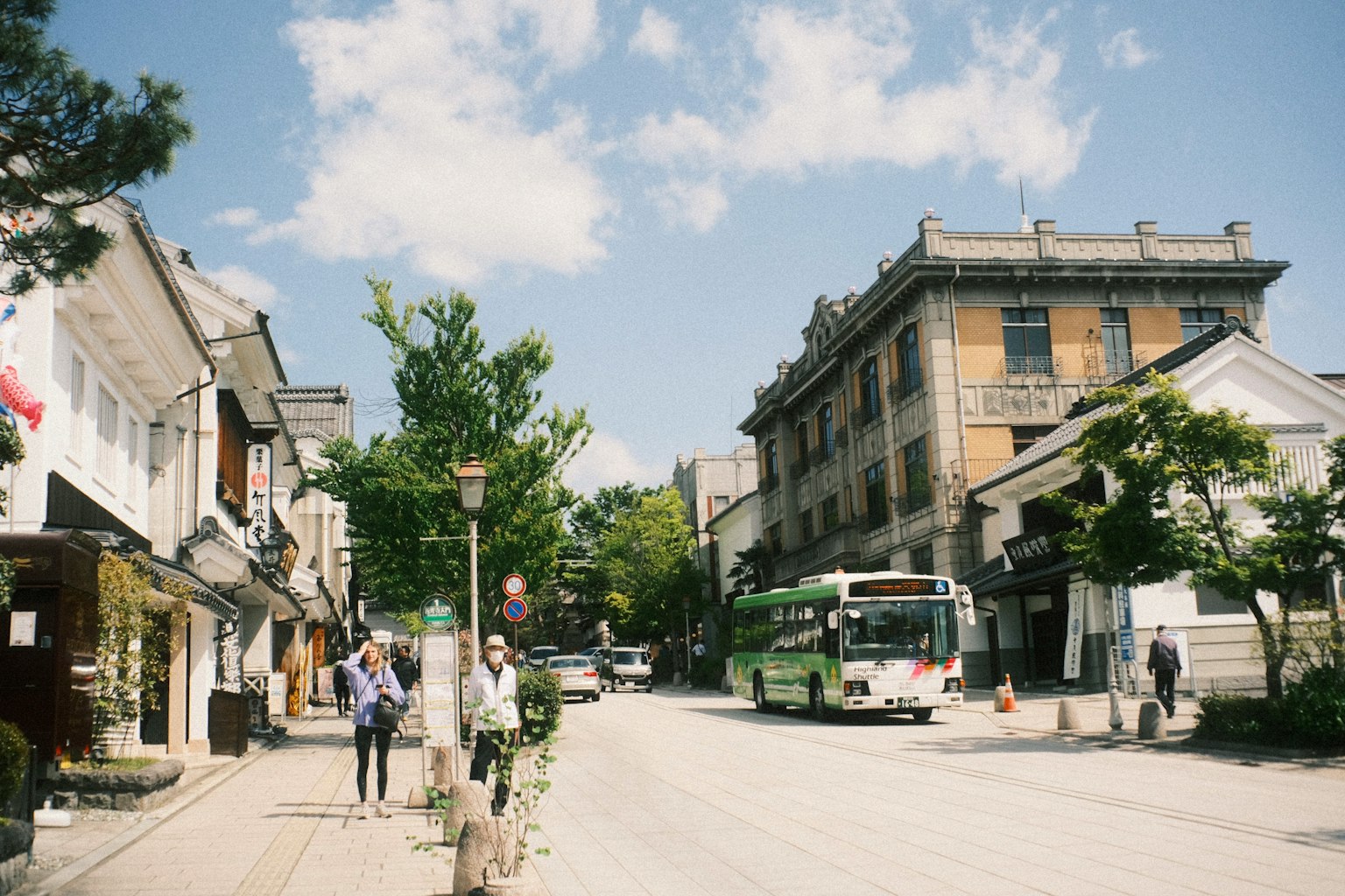 静かな街並みと青空の下のバスと人々