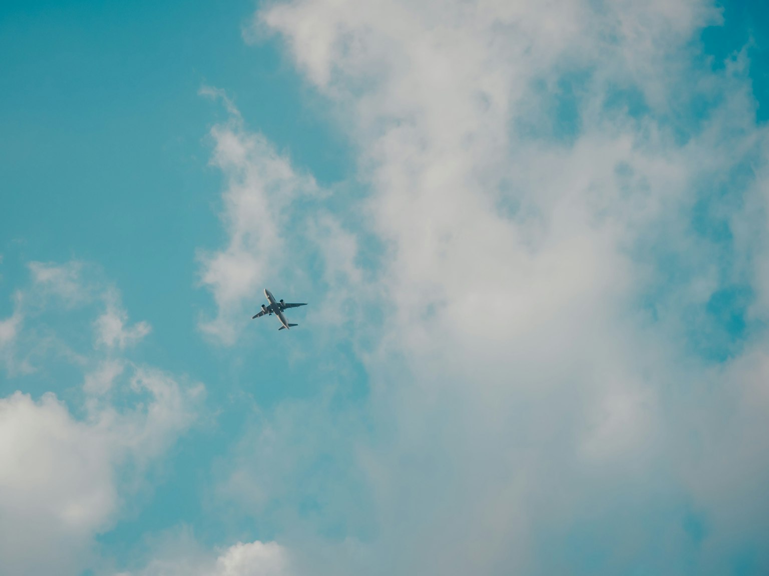 Airplane flying in a blue sky with white clouds