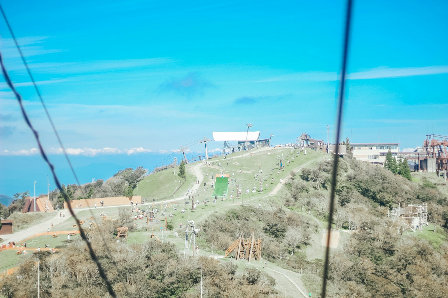 Grüne Hügel unter blauem Himmel mit Seilbahnstation
