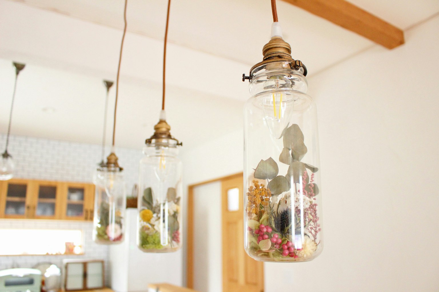 Hängende Glasbehälter mit Sukkulenten- und Blumenarrangements