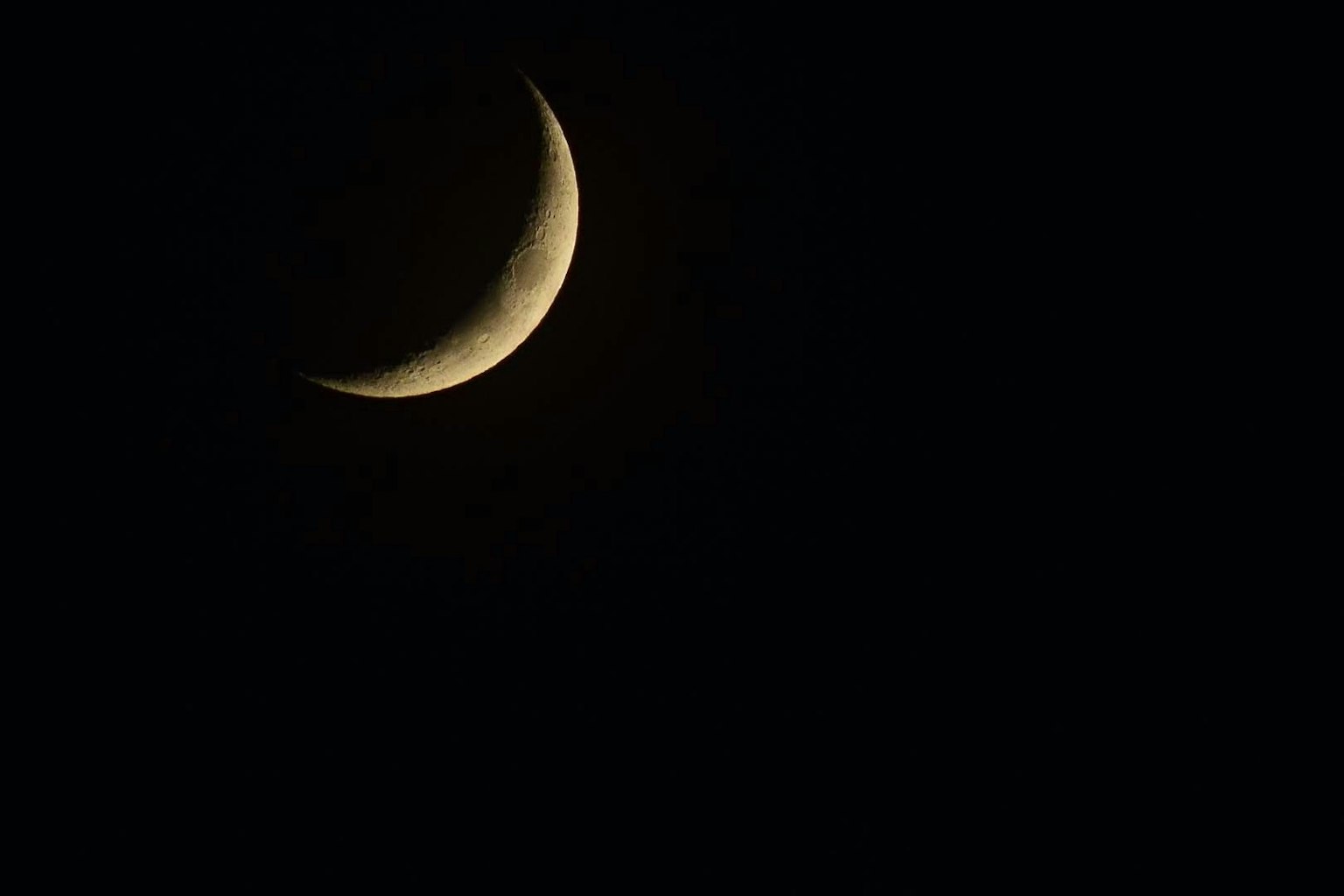 Thin crescent moon against a dark background
