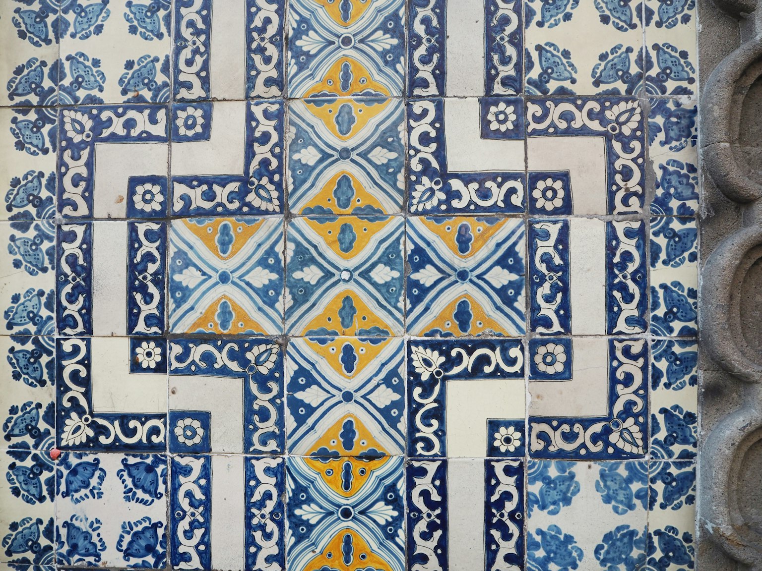 Motif de carreaux décoratifs bleus et jaunes sur un mur