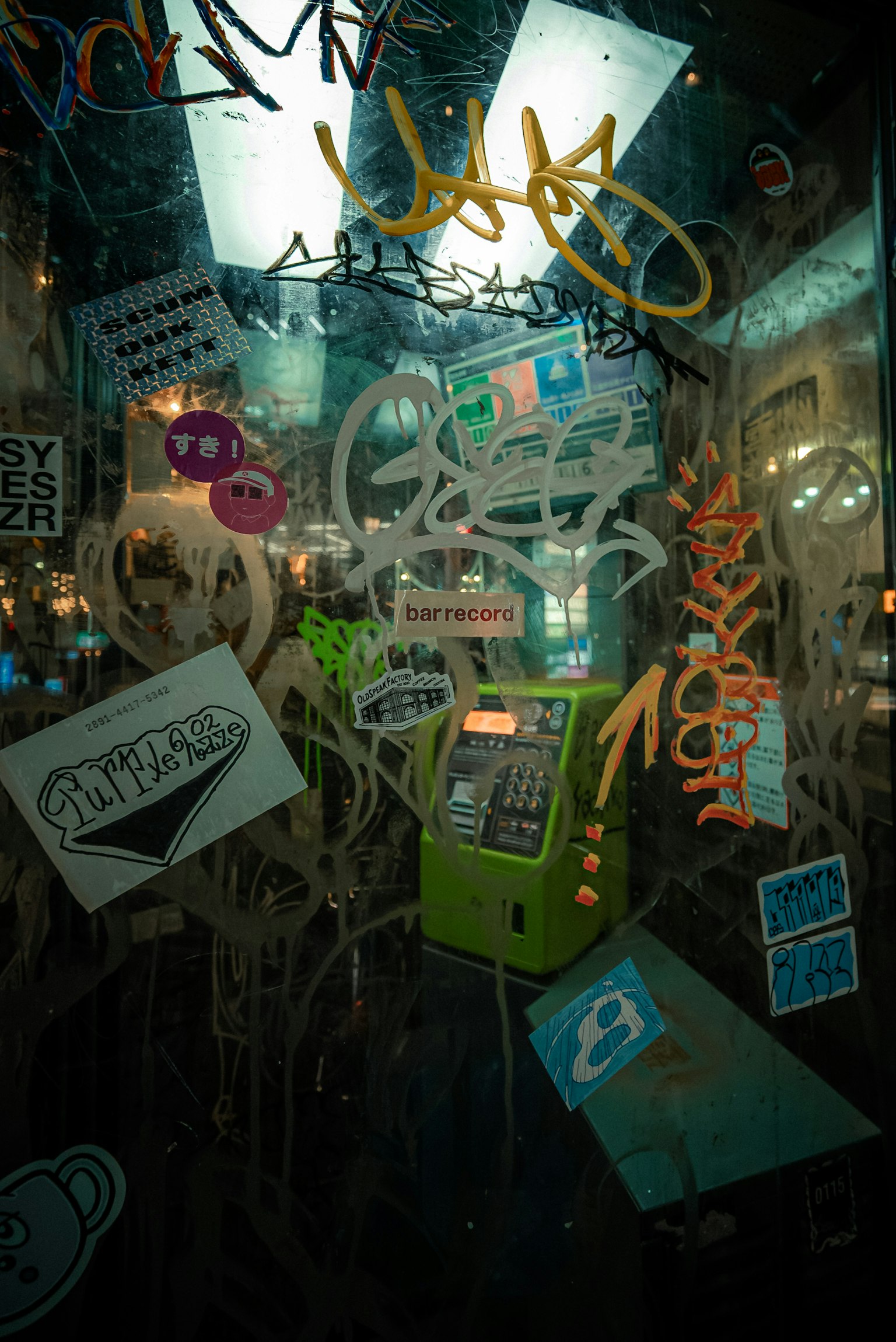 公共電話亭上有塗鴉和髒玻璃上的彩色貼紙