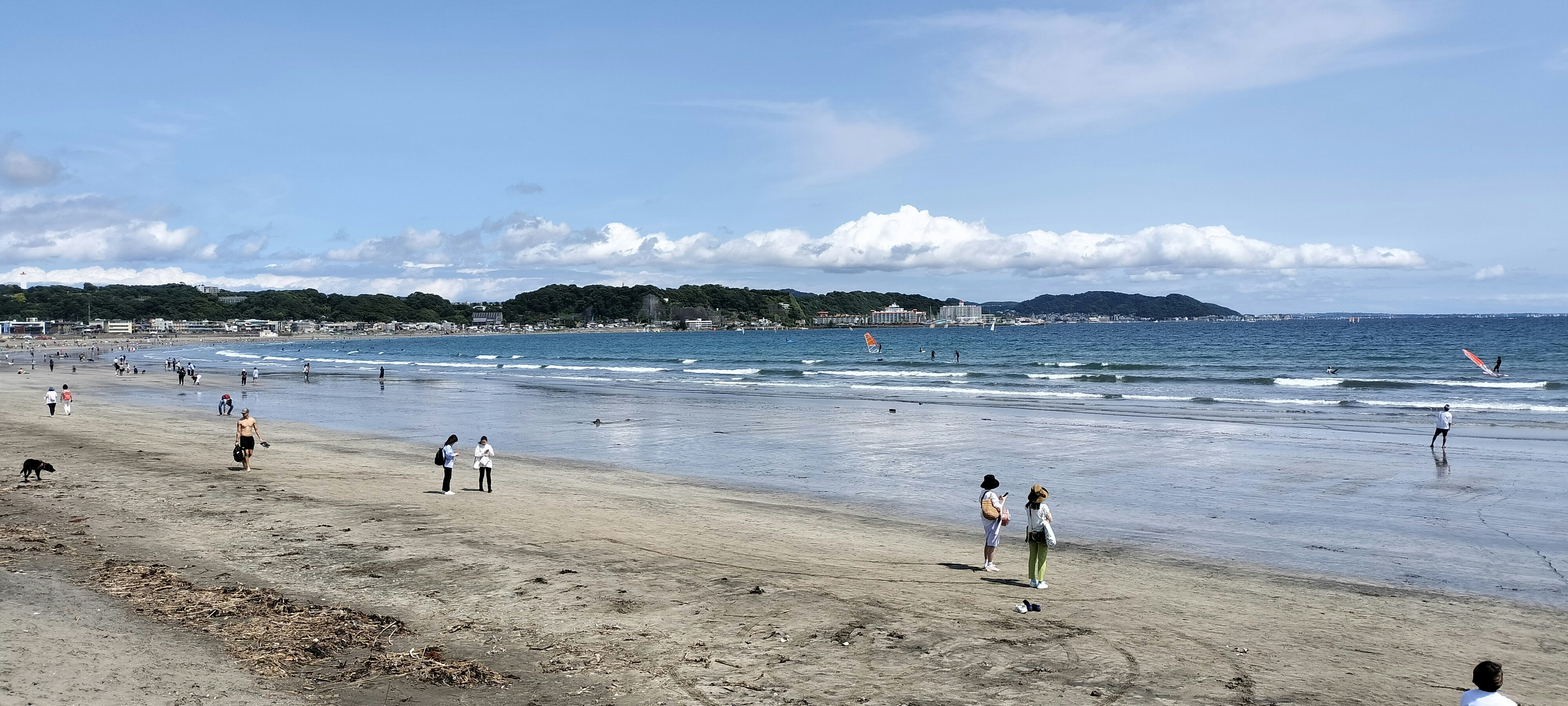 由比ヶ浜の海辺を散歩する人々と広がる砂浜