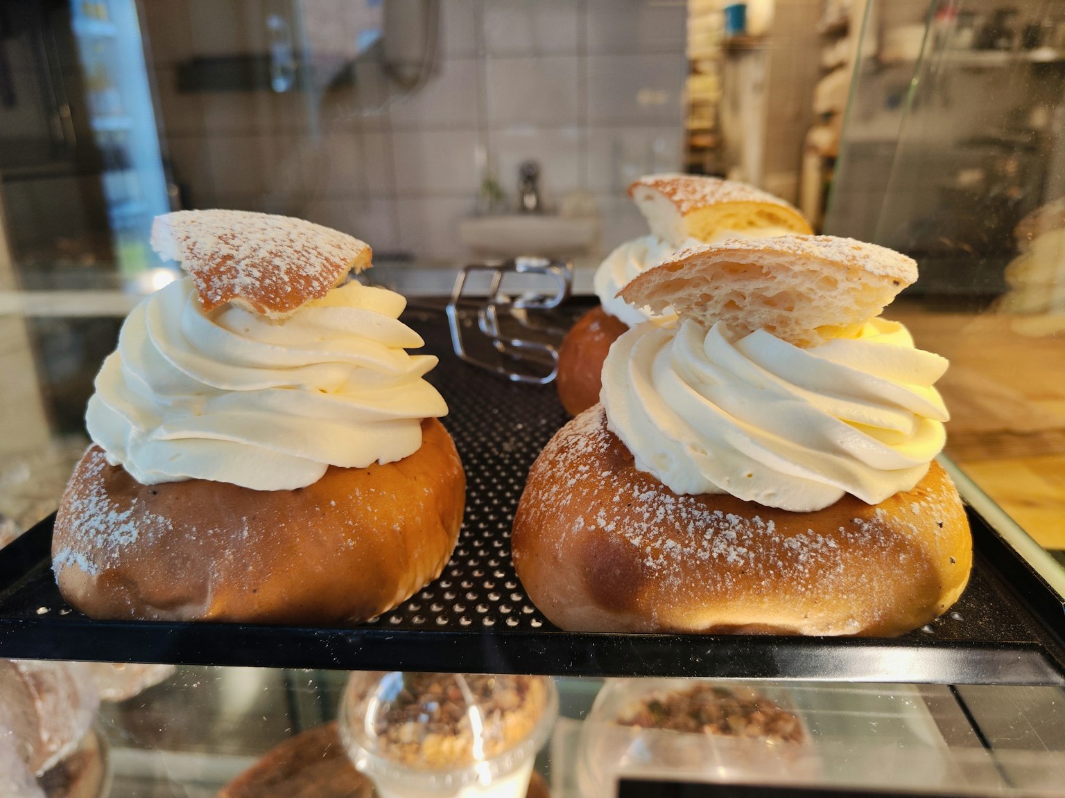 Dessert guarniti con panna montata esposti in una vetrina